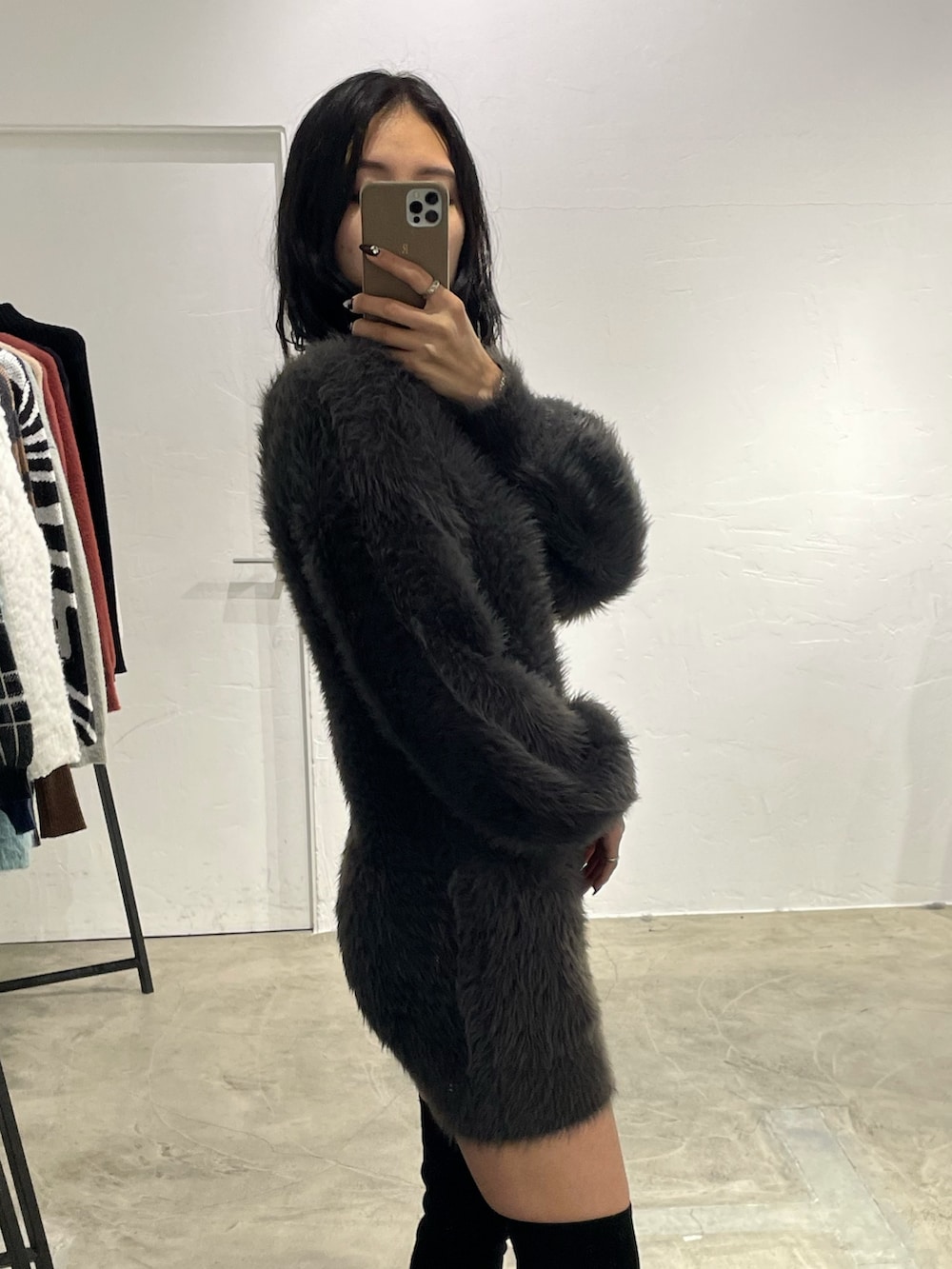 ブラック系のピーコート、グレー系のワンピース、ブラック系のブーツを着用したレディースの冬コーディネートの5枚目の写真