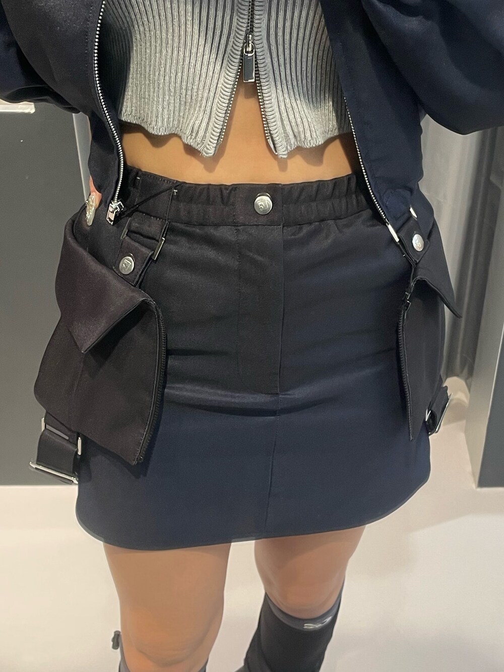 グレー系のニット/セーター、ブルー系のスカート、シルバー系のスニーカーを着用したレディースの冬コーディネートの8枚目の写真