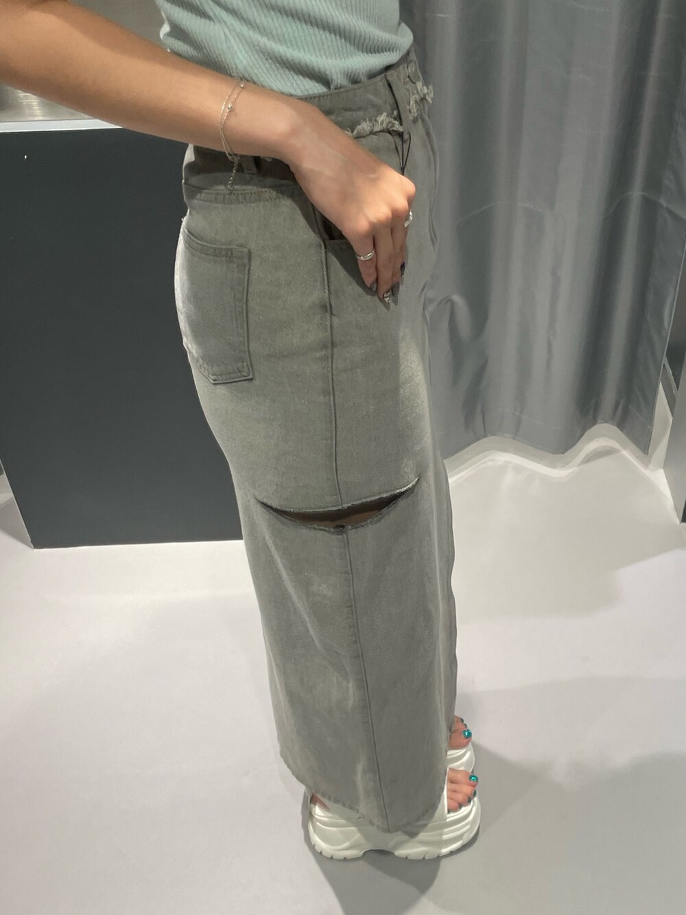 ブラック系のTシャツ/カットソー、グレー系のデニムスカート、ブラック系のサンダルを着用したレディースの夏コーディネートの7枚目の写真