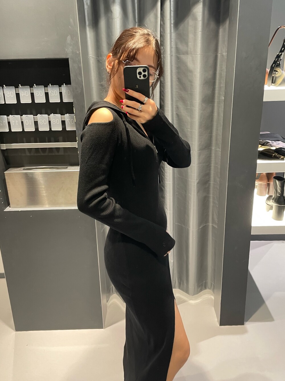 ブラック系のワンピース、ブラック系のブーツ、その他のサングラスを着用したレディースの秋コーディネートの5枚目の写真