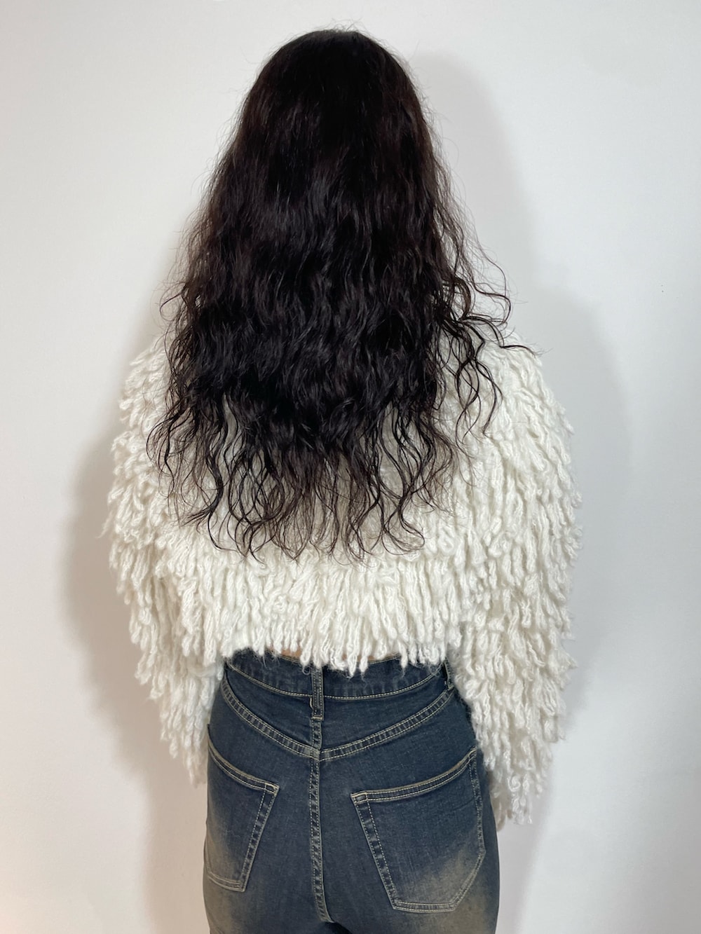 ホワイト系のニット/セーター、ブルー系のデニムパンツ、ブラウン系のショルダーバッグを着用したレディースの秋コーディネートの6枚目の写真