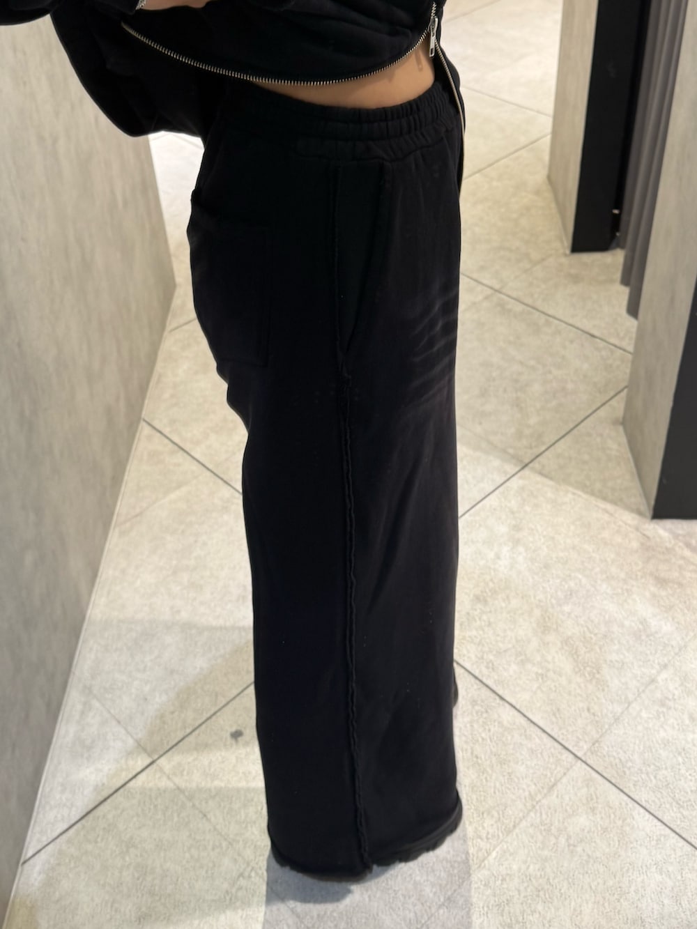 ブラック系のパーカー、ブラック系のスウェットパンツ、ブラック系のブーツを着用したレディースの秋コーディネートの7枚目の写真