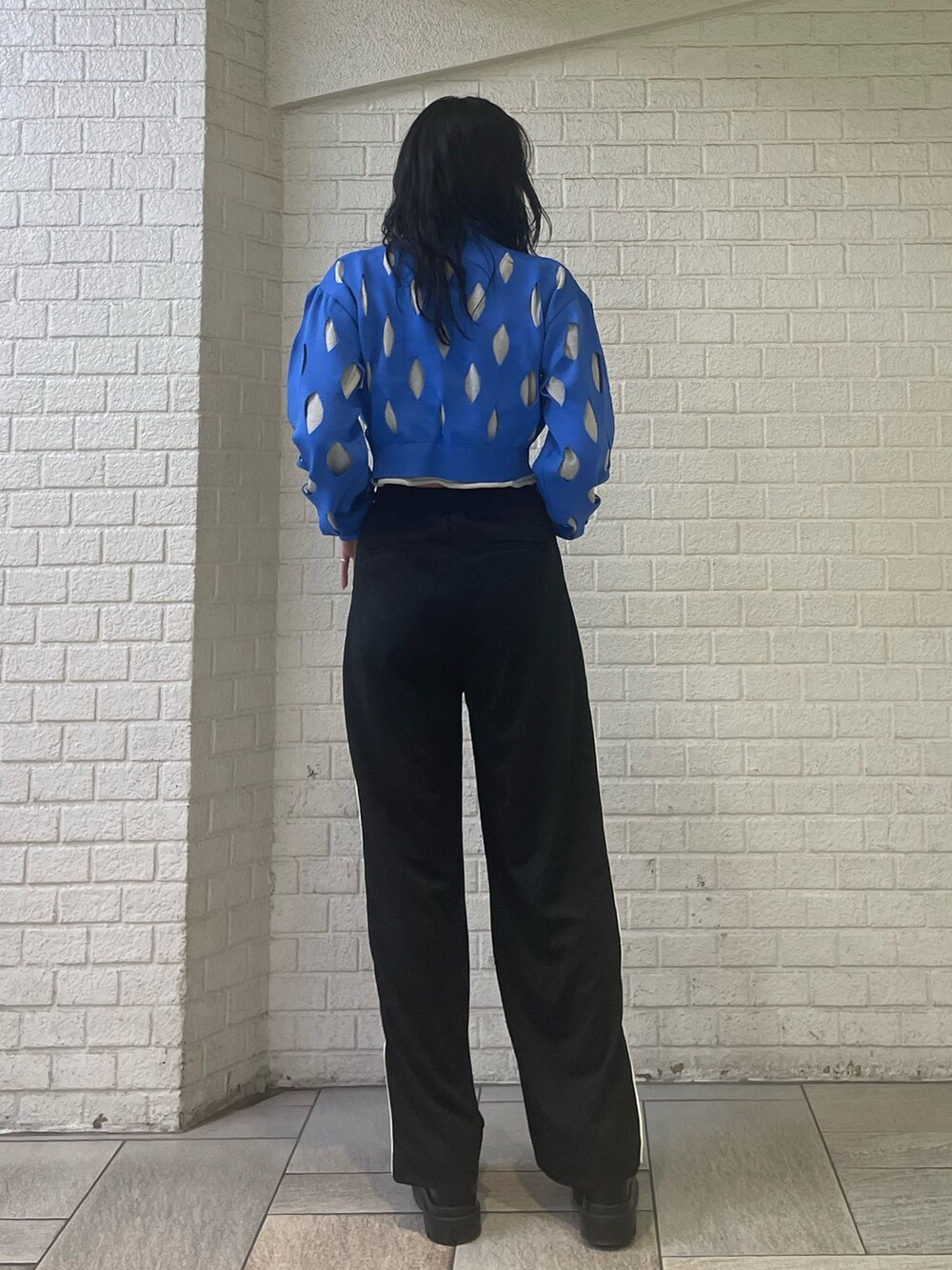 ブルー系のニット/セーター、ブラック系のスラックス、ブラック系のローファーを着用したレディースの冬コーディネートの3枚目の写真