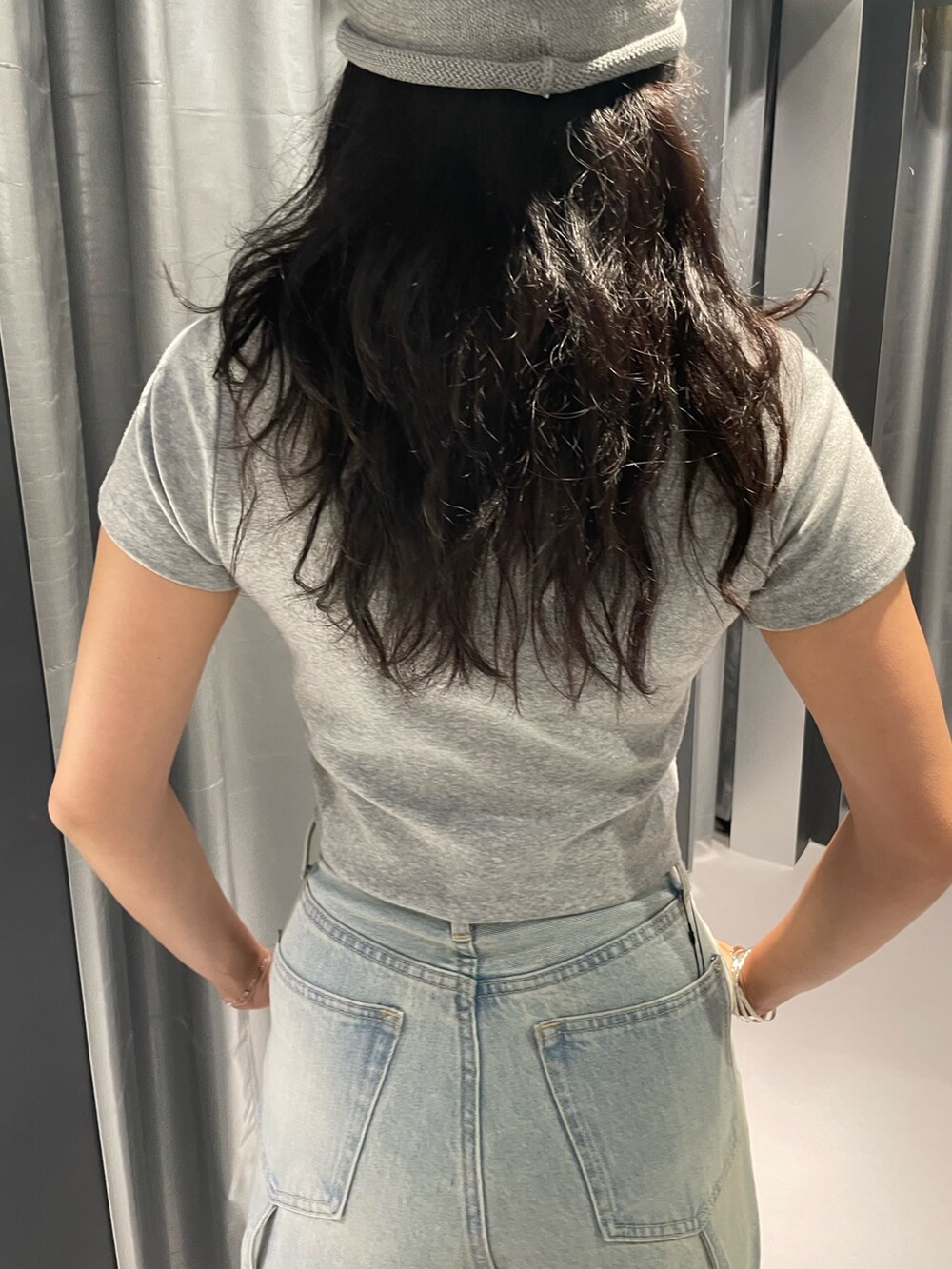 グレー系のTシャツ/カットソー、ブルー系のデニムパンツ、ホワイト系のサンダルを着用したレディースの夏コーディネートの6枚目の写真