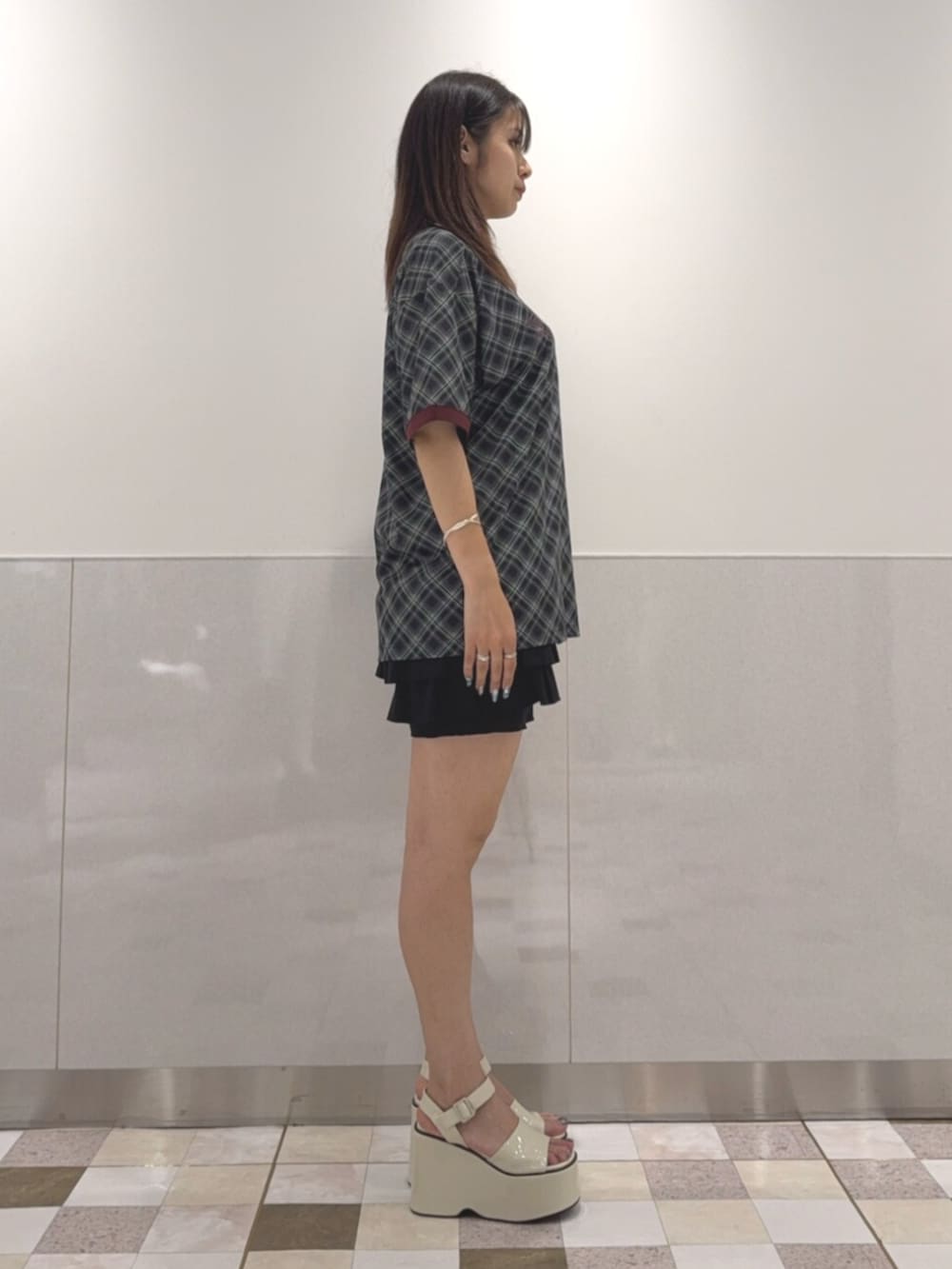 ブラック系のTシャツ/カットソー、ブラック系のスカート、ホワイト系のサンダルを着用したレディースの夏コーディネートの2枚目の写真