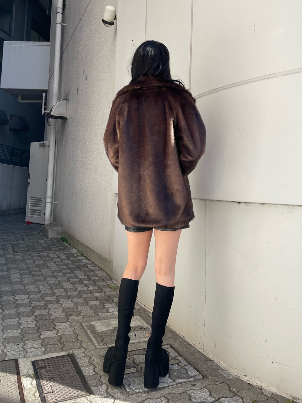 ブラック系のニット/セーター、ブラウン系のその他アウター、ブラック系のその他パンツを着用したレディースの冬コーディネートの3枚目の写真