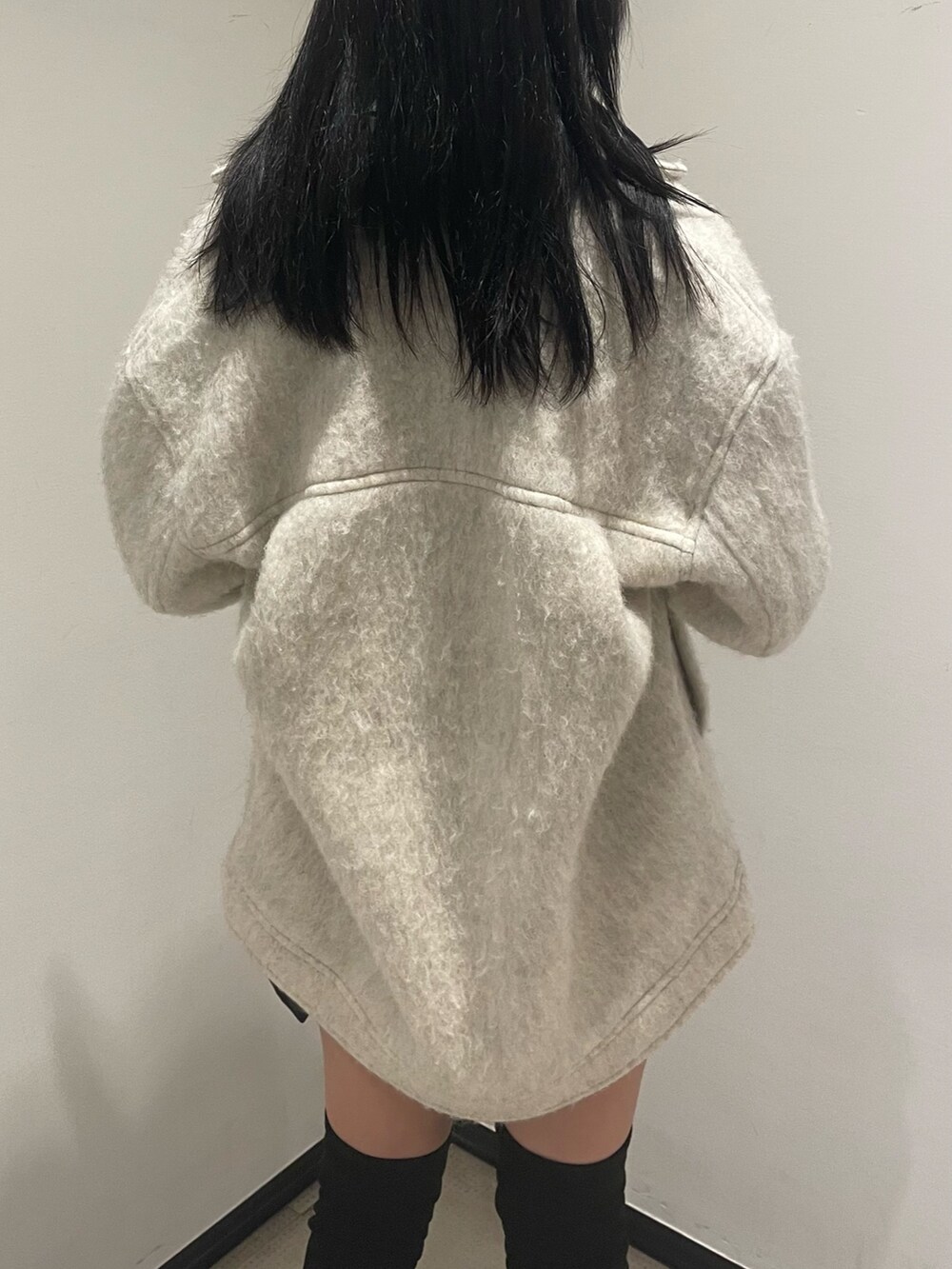 ホワイト系のニット/セーター、ホワイト系のピーコート、ブラック系のスカートを着用したレディースの冬コーディネートの6枚目の写真