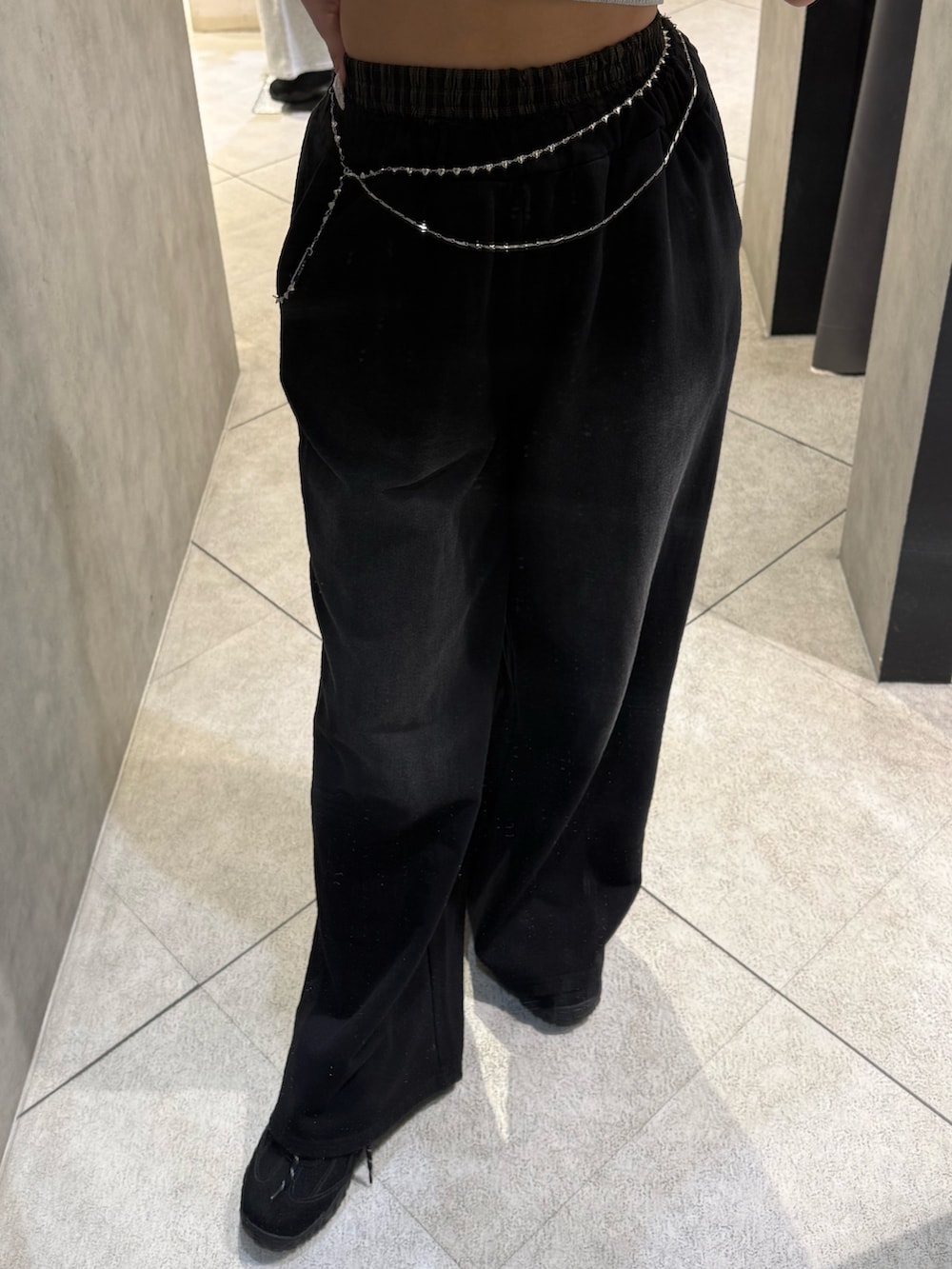 グレー系のニット/セーター、ブラック系のスウェットパンツ、ブラック系のスニーカーを着用したレディースの春コーディネートの5枚目の写真