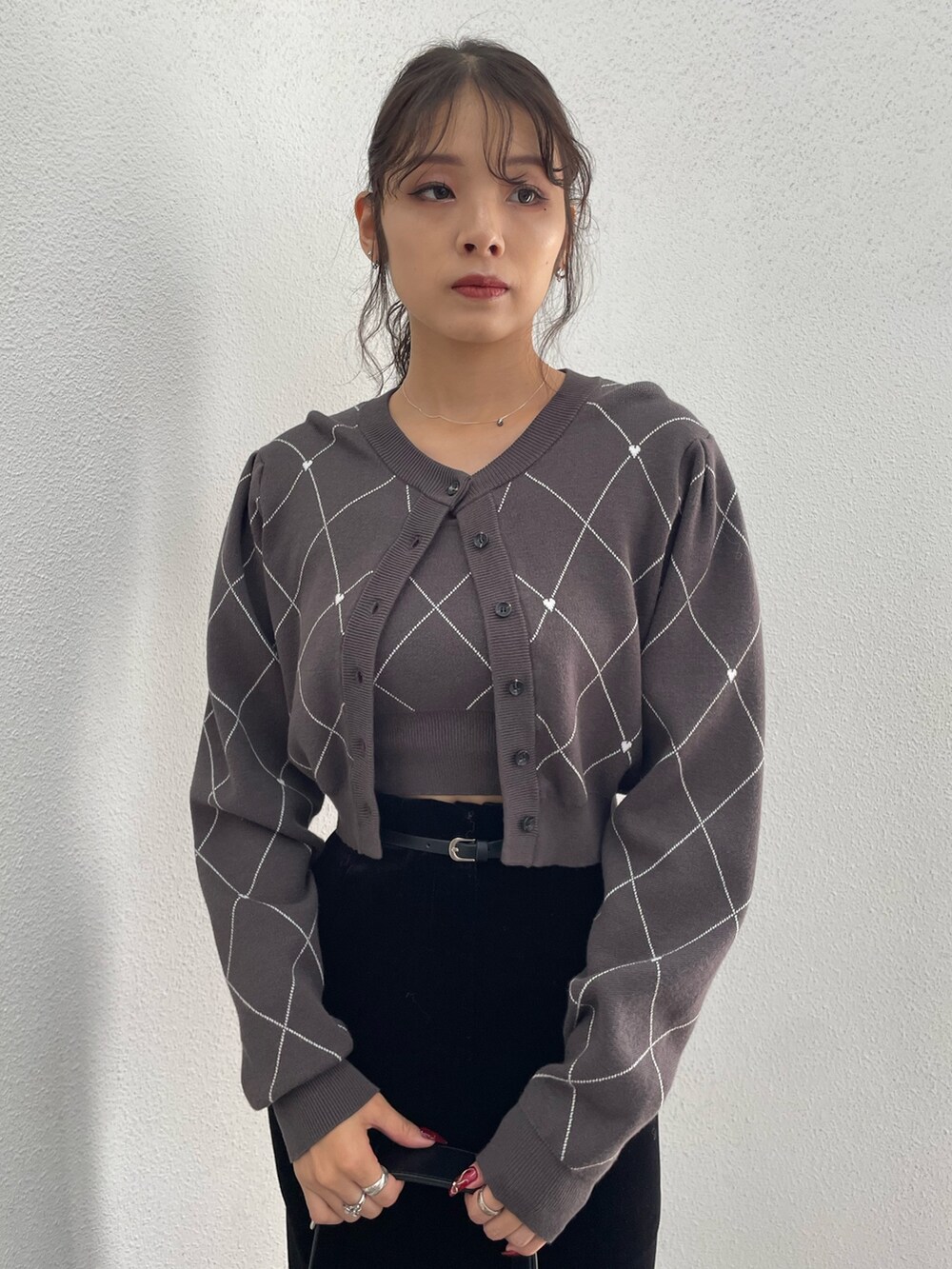 グレー系のニット/セーター、ブラック系のハンドバッグ、ブラック系のスカートを着用したレディースの秋コーディネートの4枚目の写真