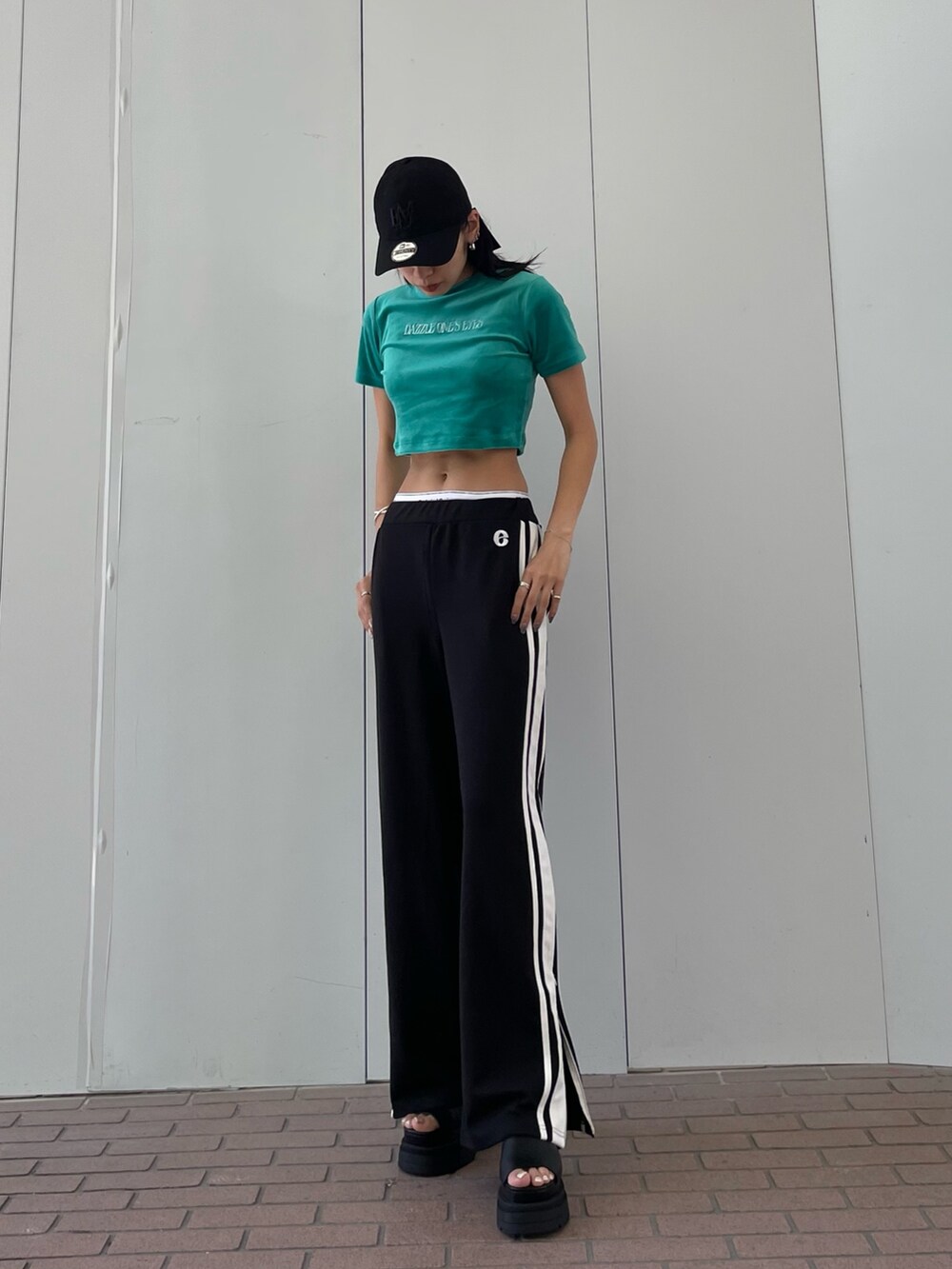 グリーン系のTシャツ/カットソー、ブラック系のその他パンツ、ブラック系のサンダルを着用したレディースの夏コーディネートの2枚目の写真