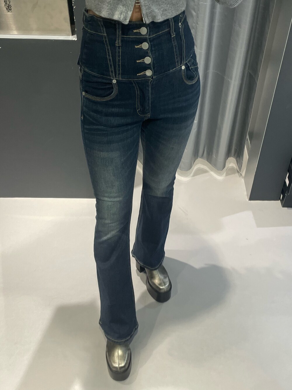 グレー系のニット/セーター、ブルー系のデニムパンツ、シルバー系のショルダーバッグを着用したレディースの冬コーディネートの6枚目の写真