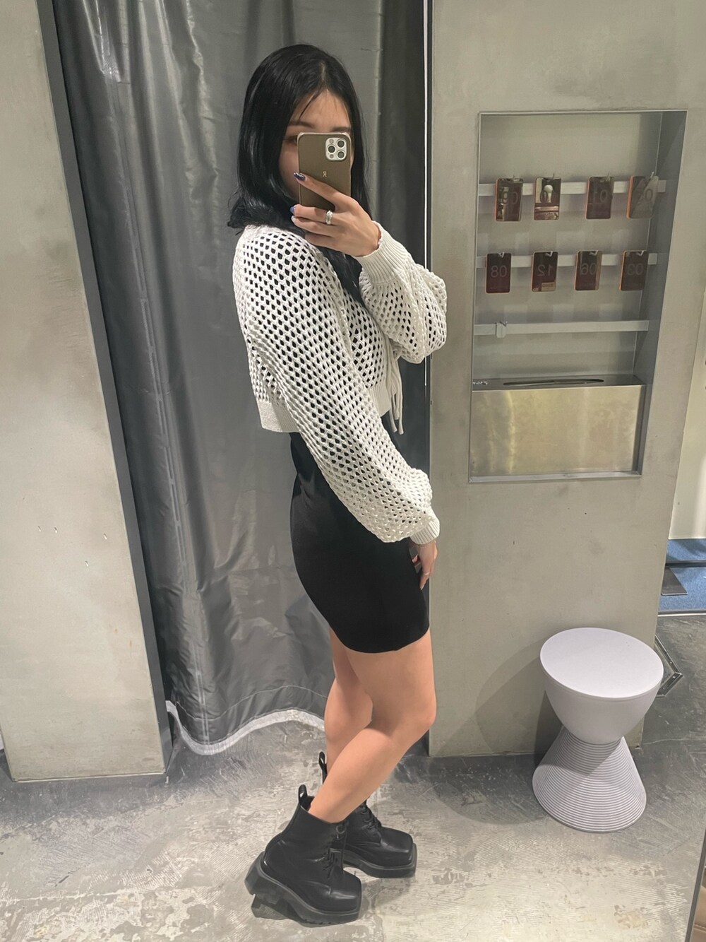 ホワイト系のワンピース、ブラック系のブーツを着用したレディースの冬コーディネートの2枚目の写真