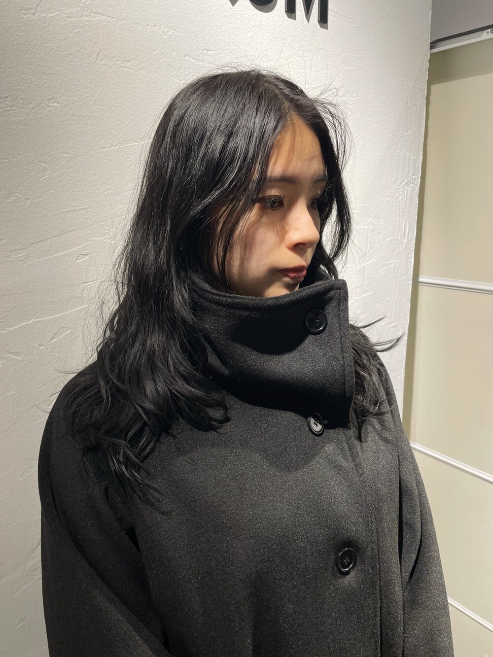 ブラック系のピーコート、グレー系のワンピース、ブラック系のブーツを着用したレディースの冬コーディネートの7枚目の写真