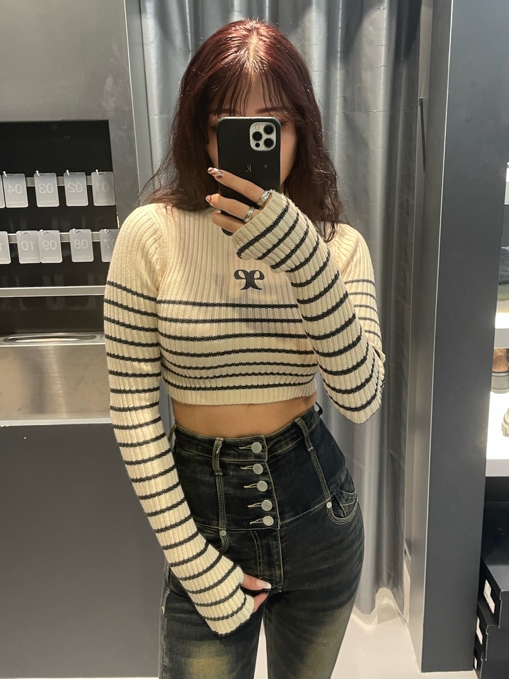 ホワイト系のニット/セーター、グレー系のブルゾン、ブルー系のデニムパンツを着用したレディースの秋コーディネートの6枚目の写真