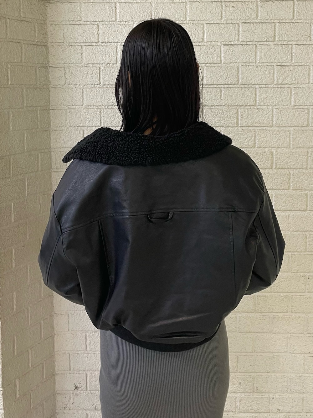 ブラック系のブルゾン、グレー系のワンピース、ブラック系のブーツを着用したレディースの秋コーディネートの6枚目の写真