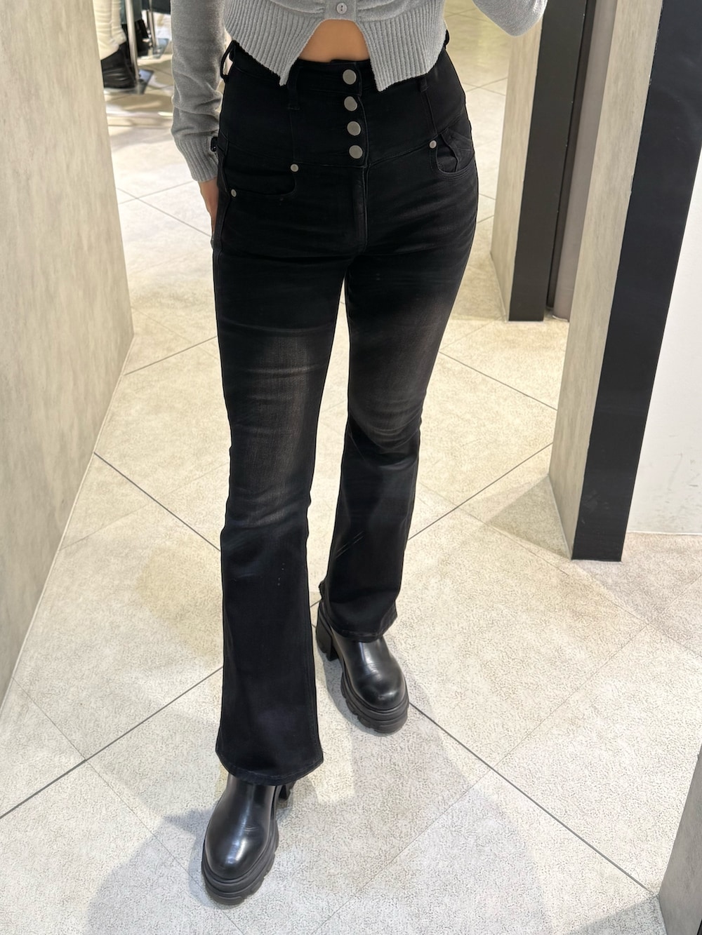 グレー系のニット/セーター、ブラック系のデニムパンツ、ブラック系のブーツを着用したレディースの春コーディネートの6枚目の写真