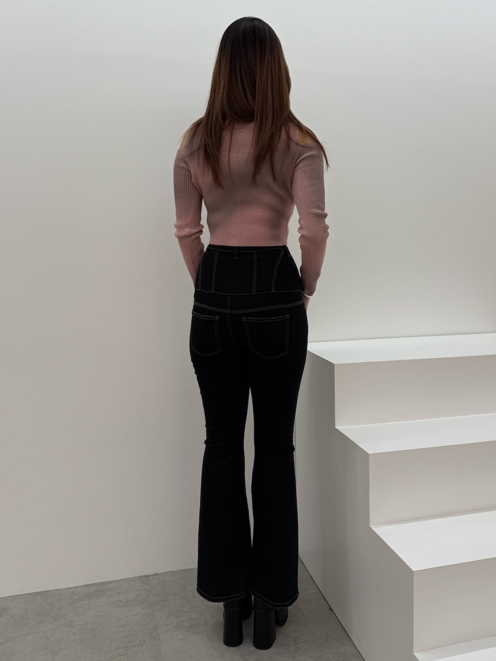 ピンク系のニット/セーター、ブラック系のデニムパンツ、ブラック系のサンダルを着用したレディースの冬コーディネートの3枚目の写真