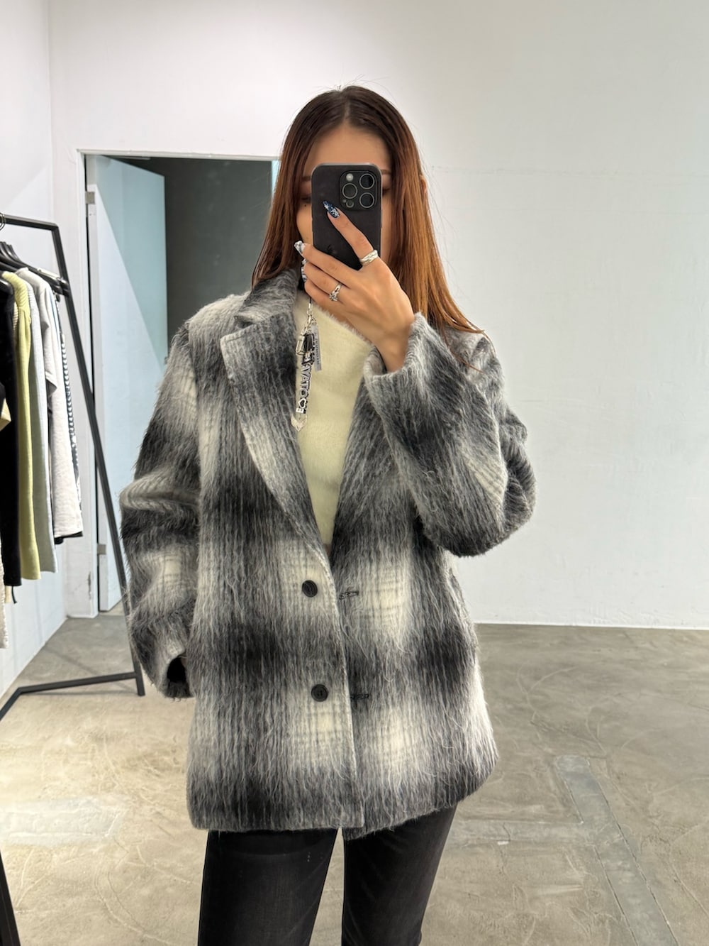 ホワイト系のニット/セーター、ブラック系のその他アウター、ブラック系のデニムパンツを着用したレディースの冬コーディネートの4枚目の写真