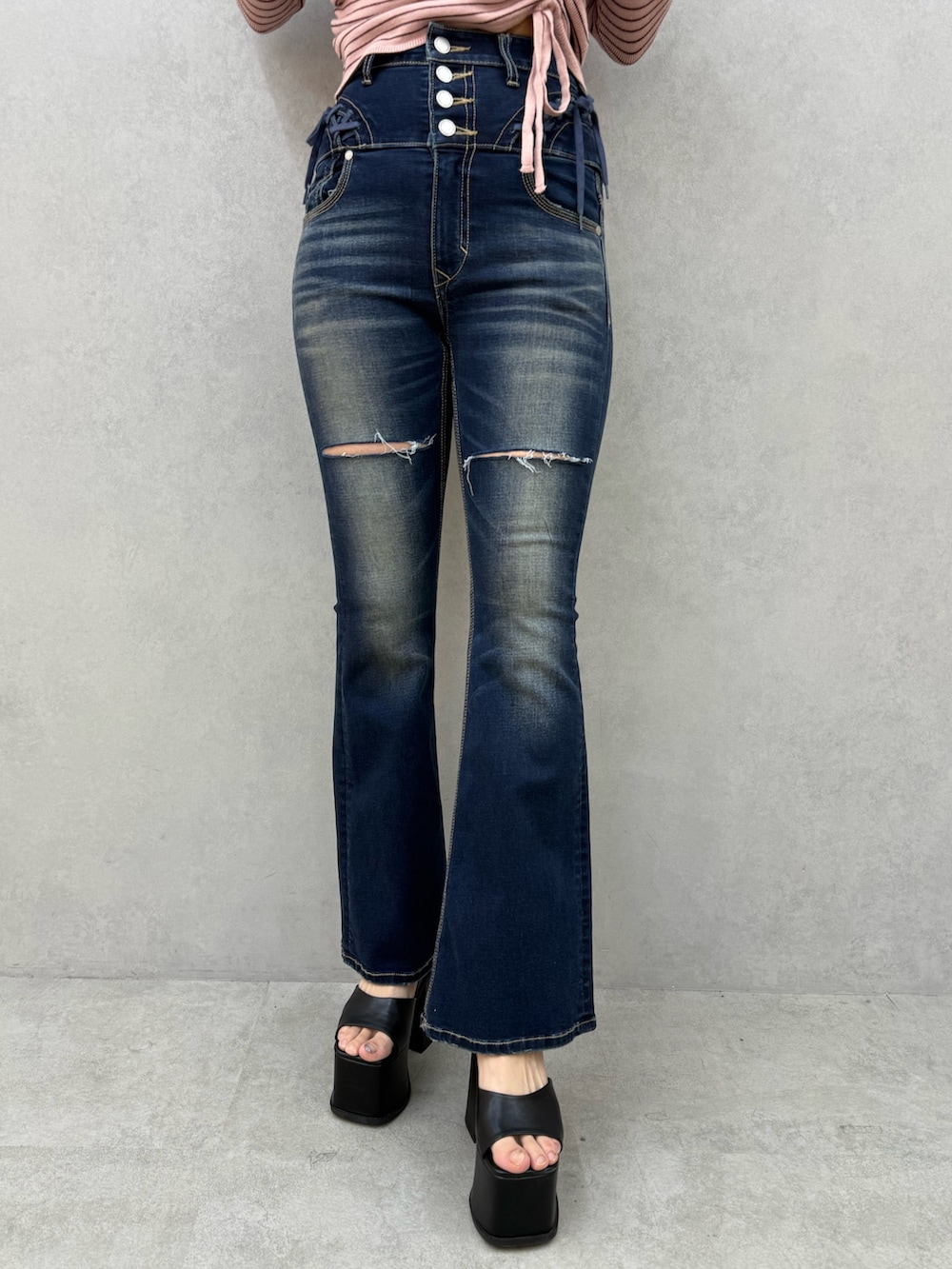 ピンク系のニット/セーター、ブルー系のデニムパンツ、ブラック系のサンダルを着用したレディースの冬コーディネートの5枚目の写真