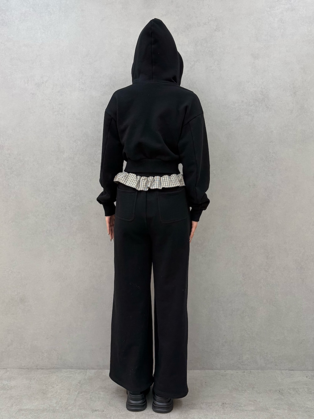 ブラック系のパーカー、ブラック系のスウェットパンツ、ブラック系のローファーを着用したレディースの冬コーディネートの3枚目の写真