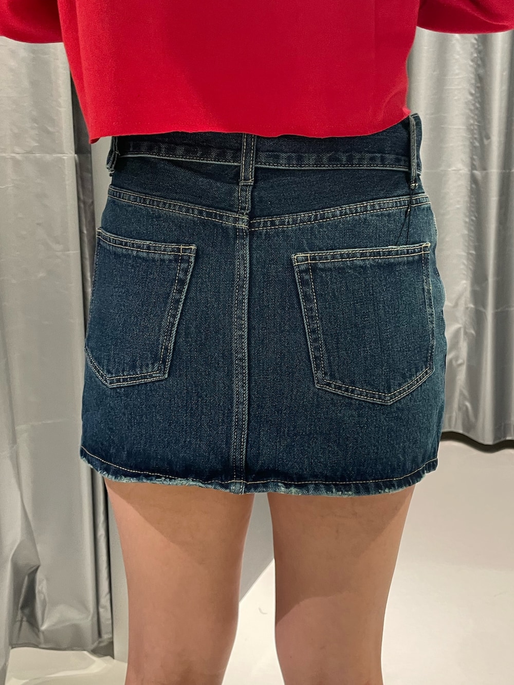 レッド系のTシャツ/カットソー、ブルー系のデニムスカート、その他のブーツを着用したレディースの秋コーディネートの9枚目の写真