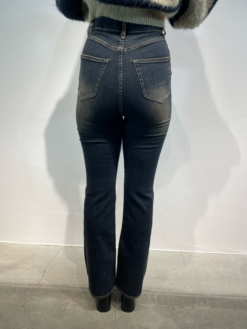 ブルー系のニット/セーター、ブルー系のデニムパンツ、シルバー系のハンドバッグを着用したレディースの秋コーディネートの9枚目の写真