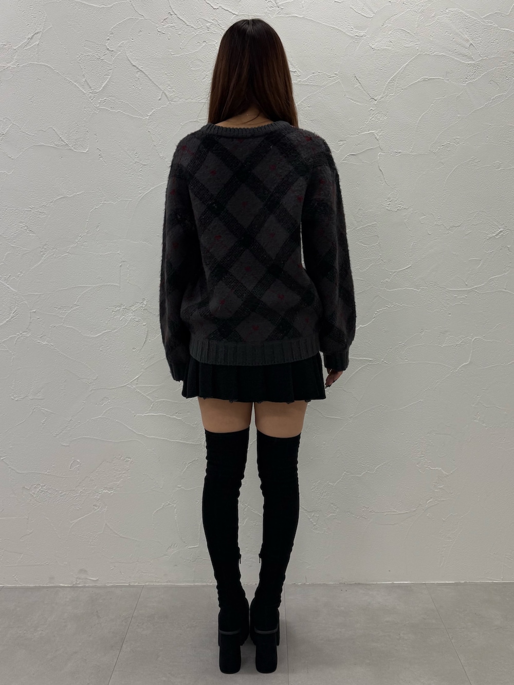 ブラック系のブーツ、グレー系のニット/セーター、ブラック系のスカートを着用したレディースの冬コーディネートの3枚目の写真