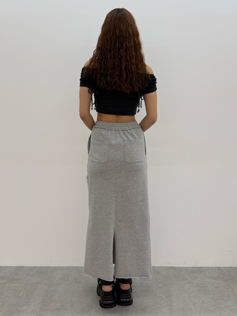 ブラック系のTシャツ/カットソー、グレー系のスカート、ブラック系のサンダルを着用したレディースの夏コーディネートの3枚目の写真