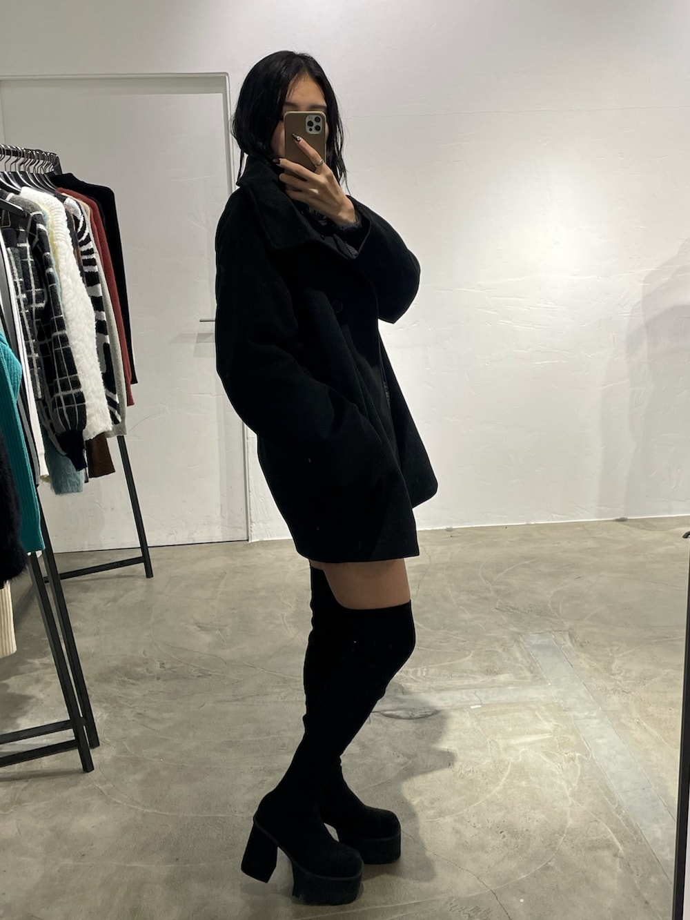 ブラック系のピーコート、グレー系のワンピース、ブラック系のブーツを着用したレディースの冬コーディネートの2枚目の写真