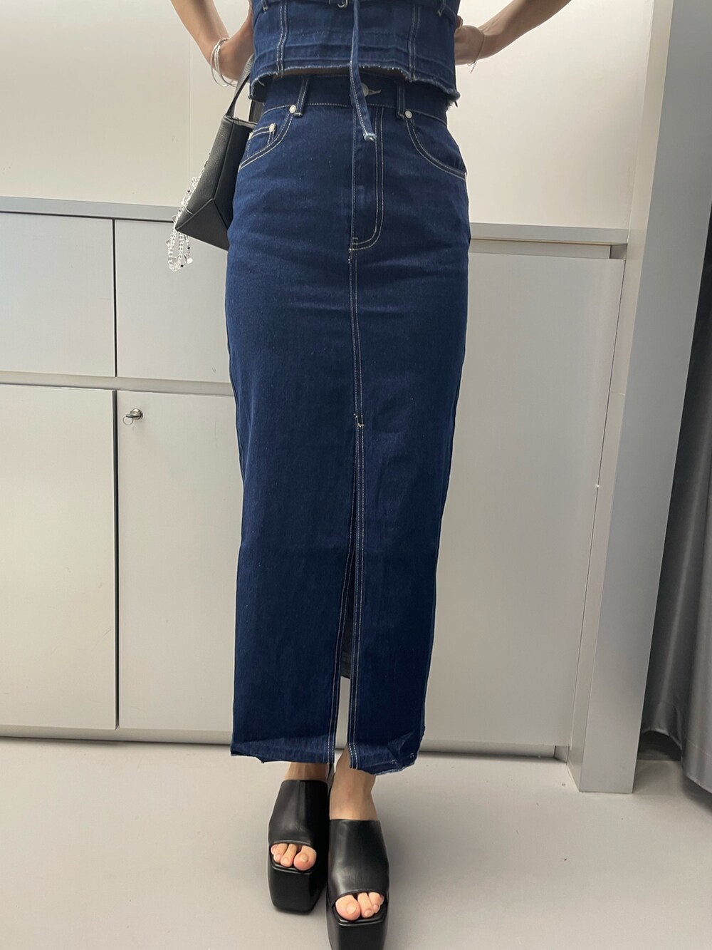 ブルー系のシャツ/ブラウス、ブルー系のスカート、ブラック系のハンドバッグを着用したレディースの春コーディネートの7枚目の写真