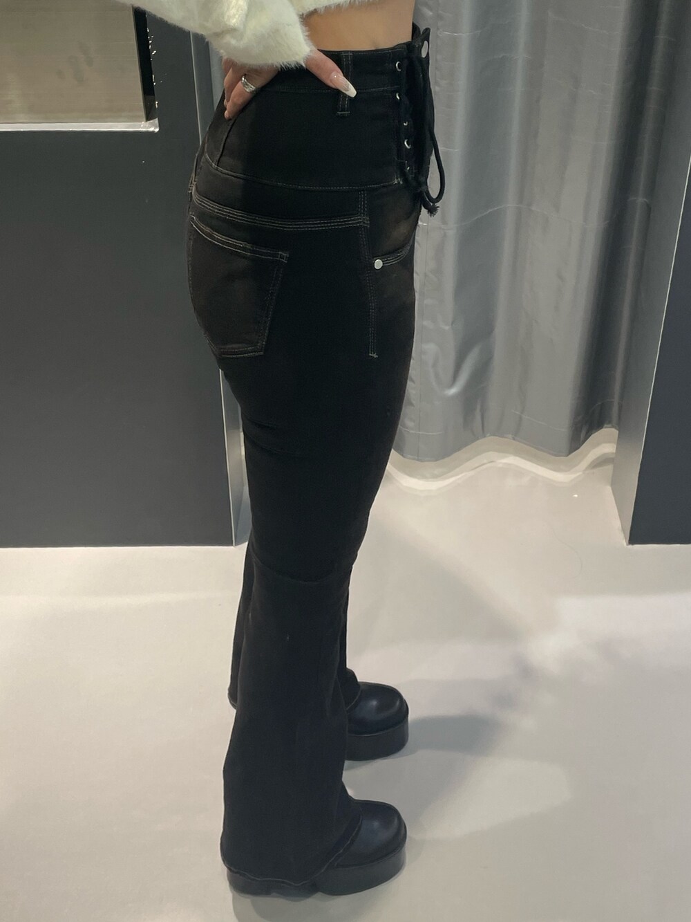 ホワイト系のニット/セーター、ブラウン系のダウンジャケット/コート、ブラック系のデニムパンツを着用したレディースの冬コーディネートの9枚目の写真