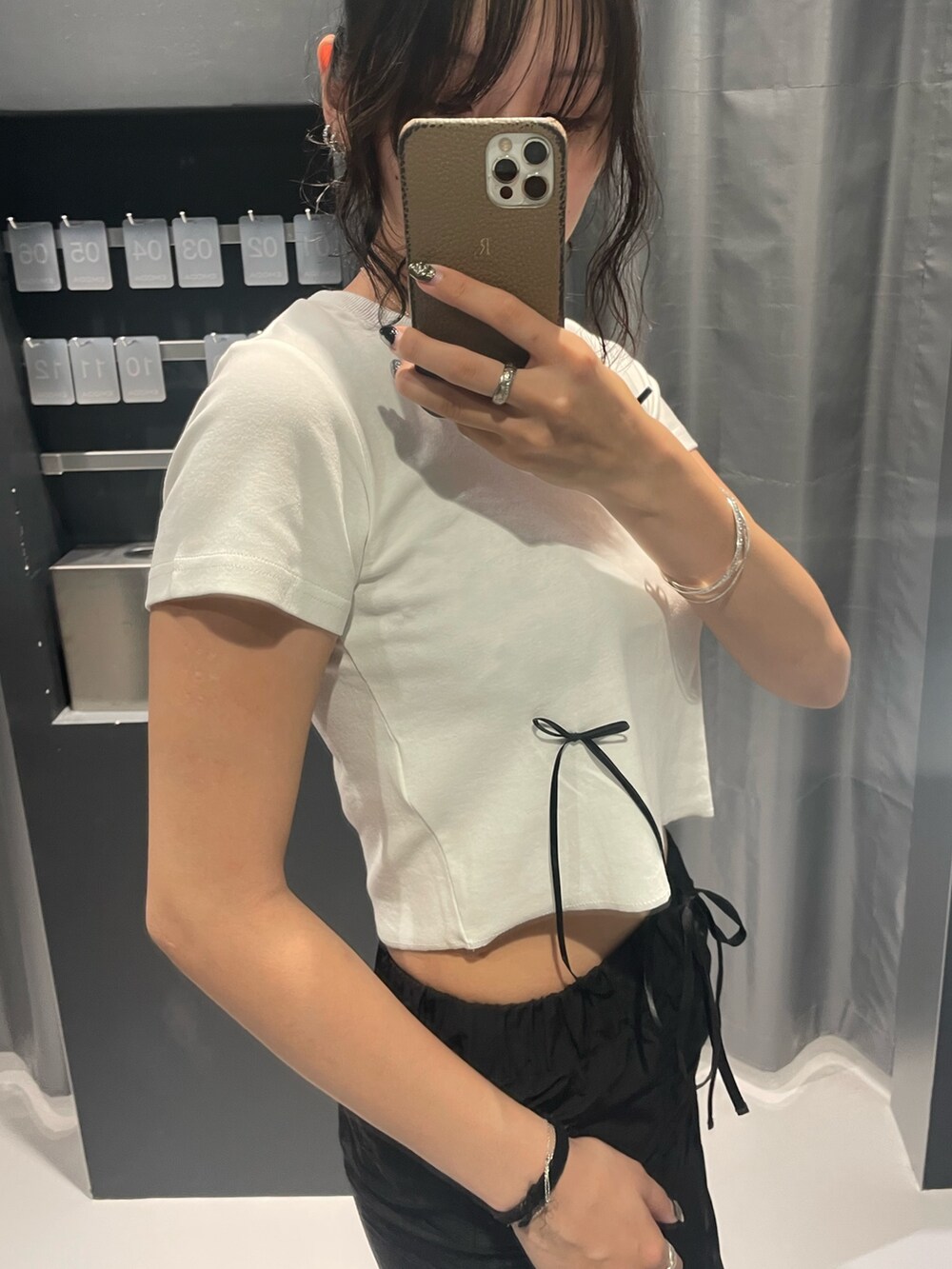 ホワイト系のTシャツ/カットソー、ブラック系のスカート、ブラック系のサンダルを着用したレディースの夏コーディネートの5枚目の写真