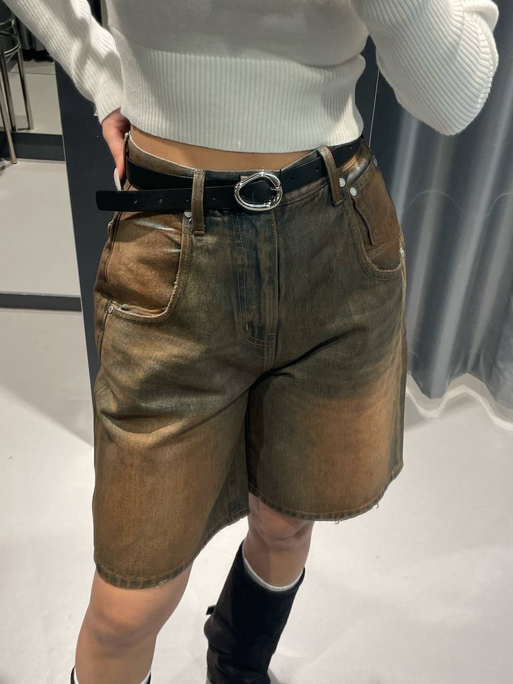 ホワイト系のニット/セーター、ブラウン系のデニムパンツ、ブラック系のブーツを着用したレディースの冬コーディネートの8枚目の写真