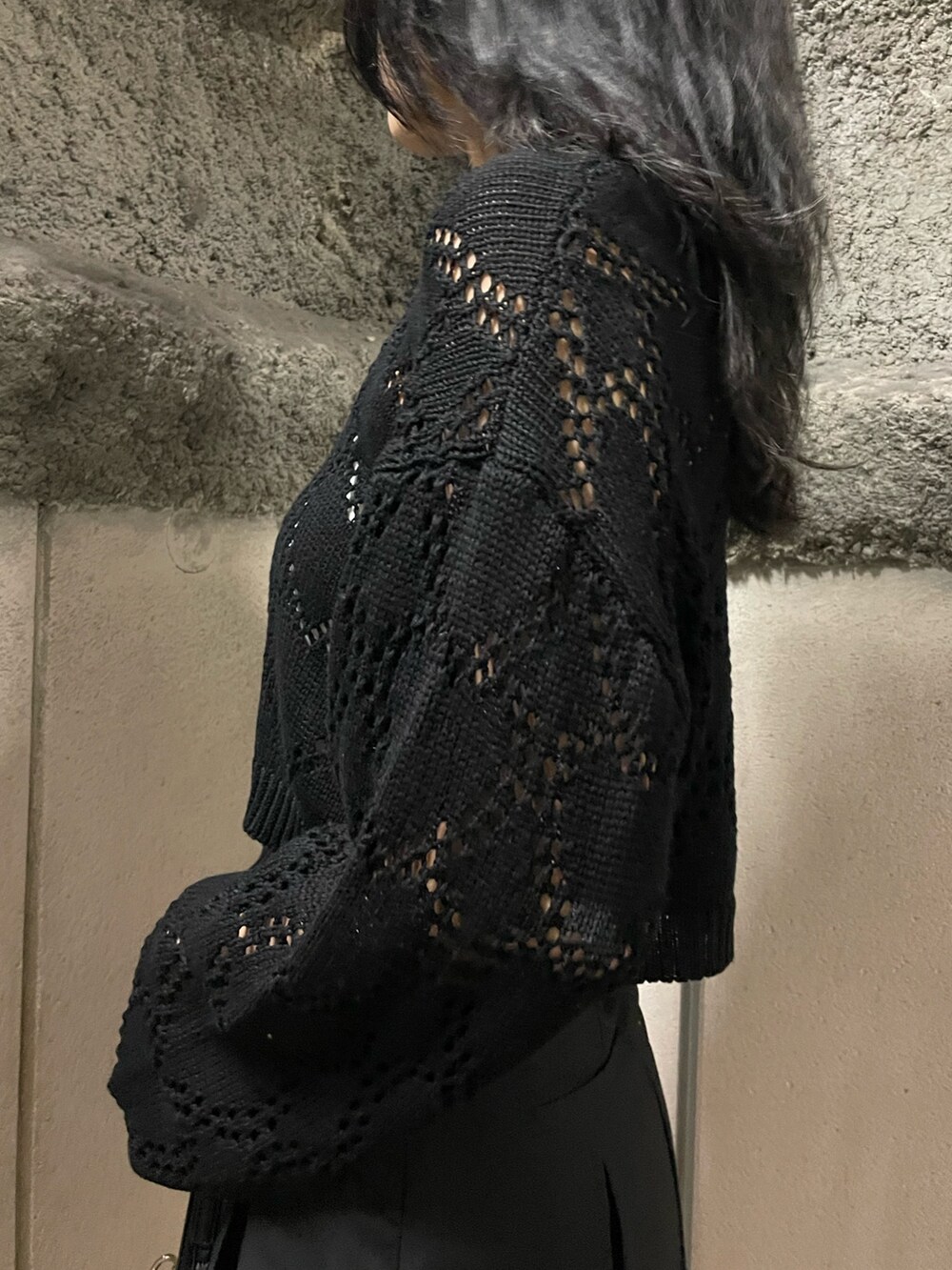 ブラック系のニット/セーター、ホワイト系のキャミソール、ブラック系のスカートを着用したレディースの春コーディネートの5枚目の写真