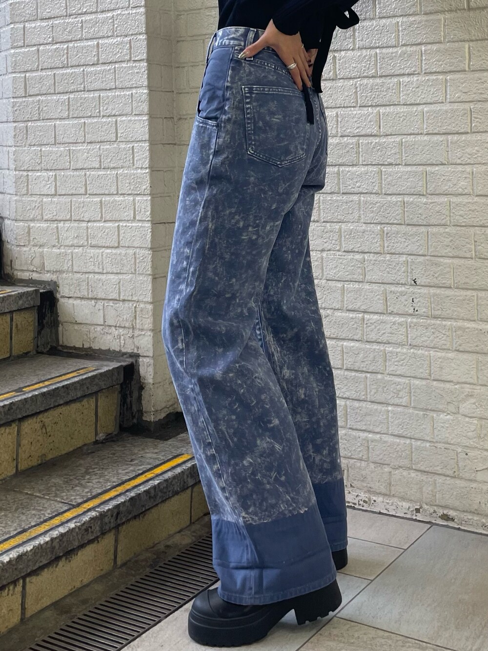 ブラック系のニット/セーター、パープル系のデニムパンツ、ブラック系のブーツを着用したレディースの秋コーディネートの8枚目の写真