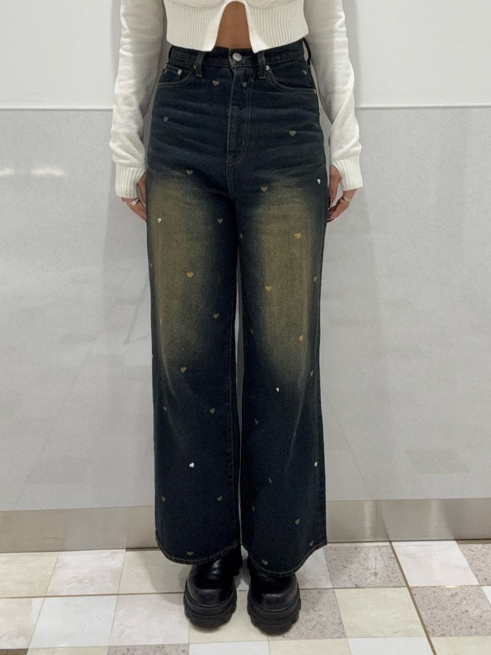 ホワイト系のニット/セーター、ブルー系のデニムパンツ、ブラック系のブーツを着用したレディースの秋コーディネートの6枚目の写真