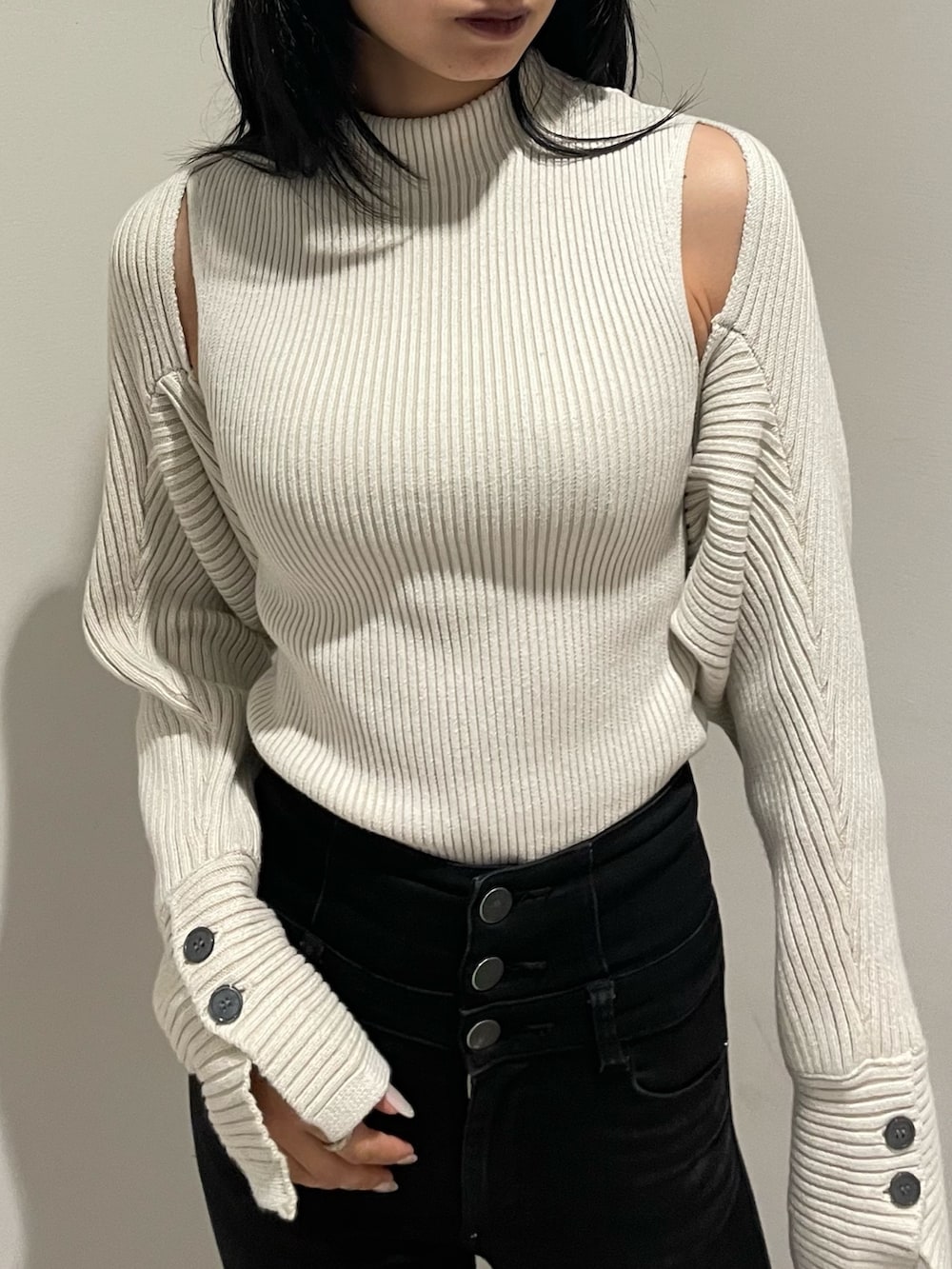 ホワイト系のニット/セーター、ブラック系のデニムパンツ、ブラック系のブーツを着用したレディースの秋コーディネートの5枚目の写真