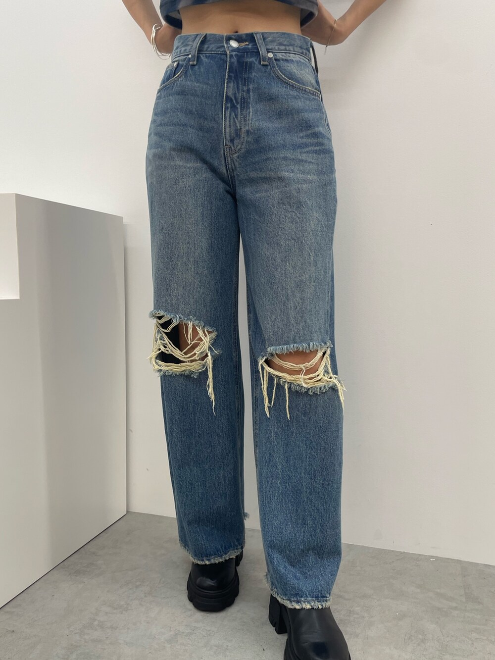 レッド系のTシャツ/カットソー、ブルー系のデニムパンツ、ブラック系のブーツを着用したレディースの秋コーディネートの7枚目の写真