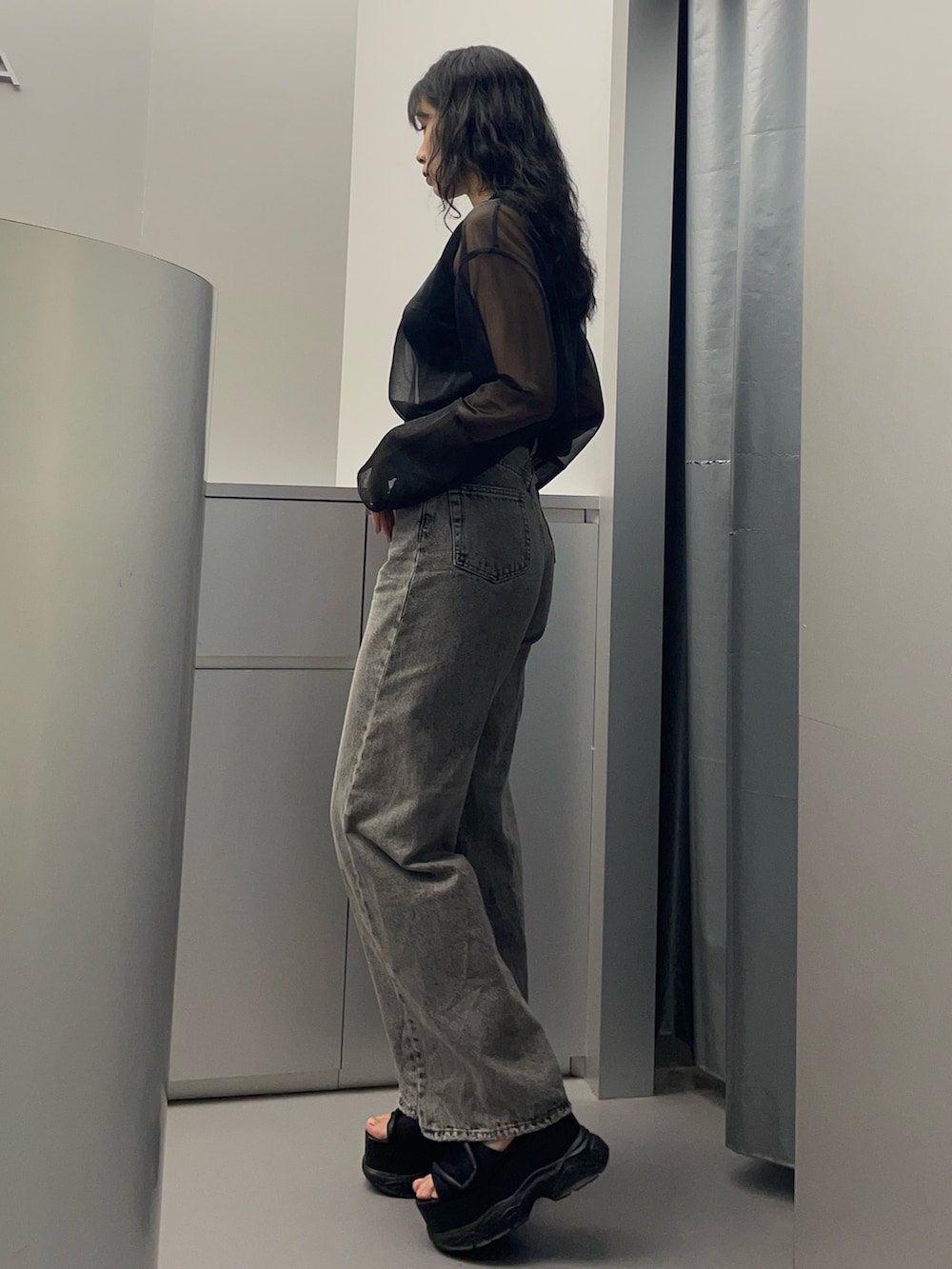 ブラック系のタンクトップ、ブラック系のTシャツ/カットソー、グレー系のデニムパンツを着用したレディースの春コーディネートの2枚目の写真