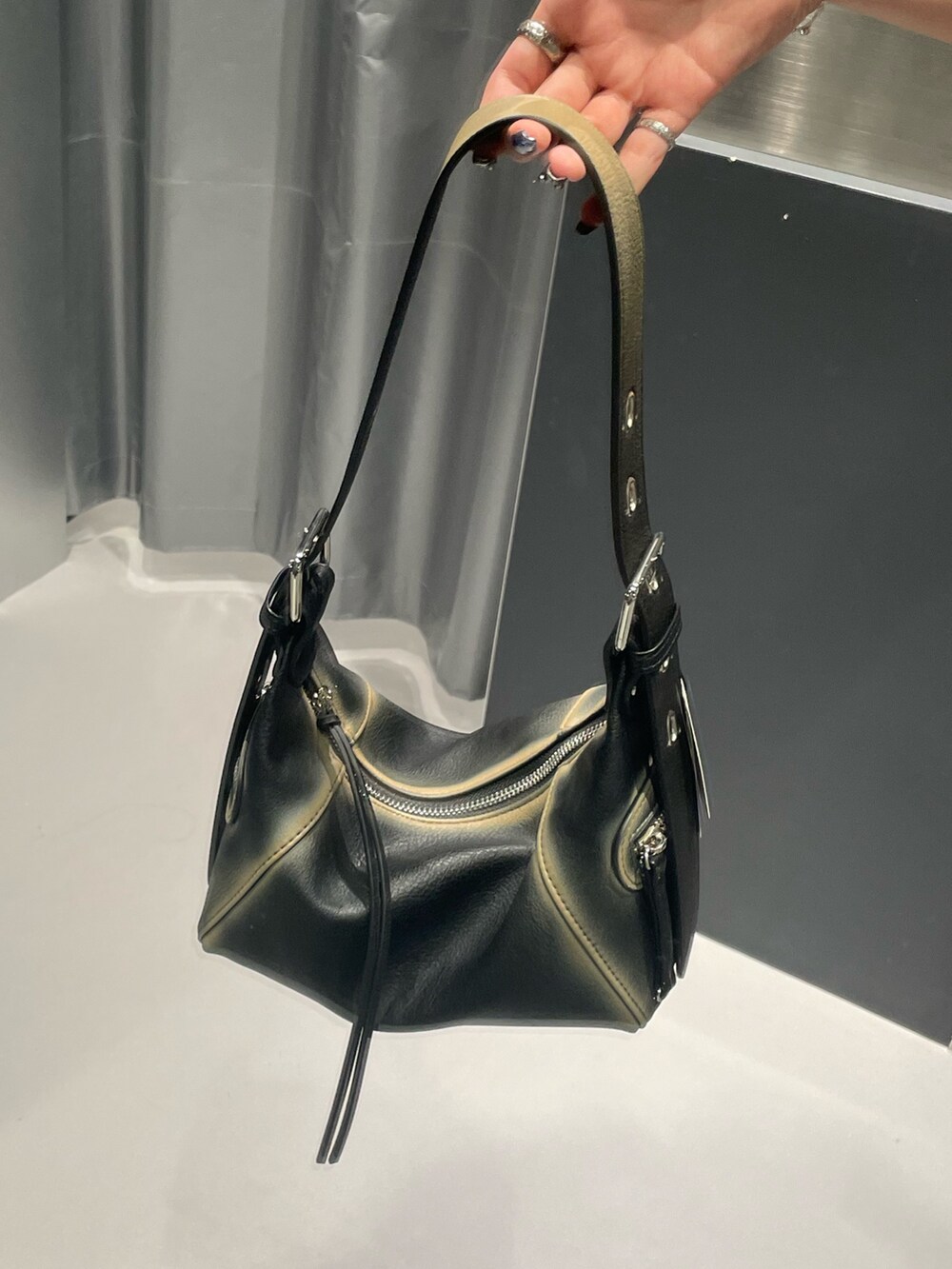 グレー系のニット/セーター、ブルー系のデニムパンツ、ブラック系のハンドバッグを着用したレディースの秋コーディネートの9枚目の写真