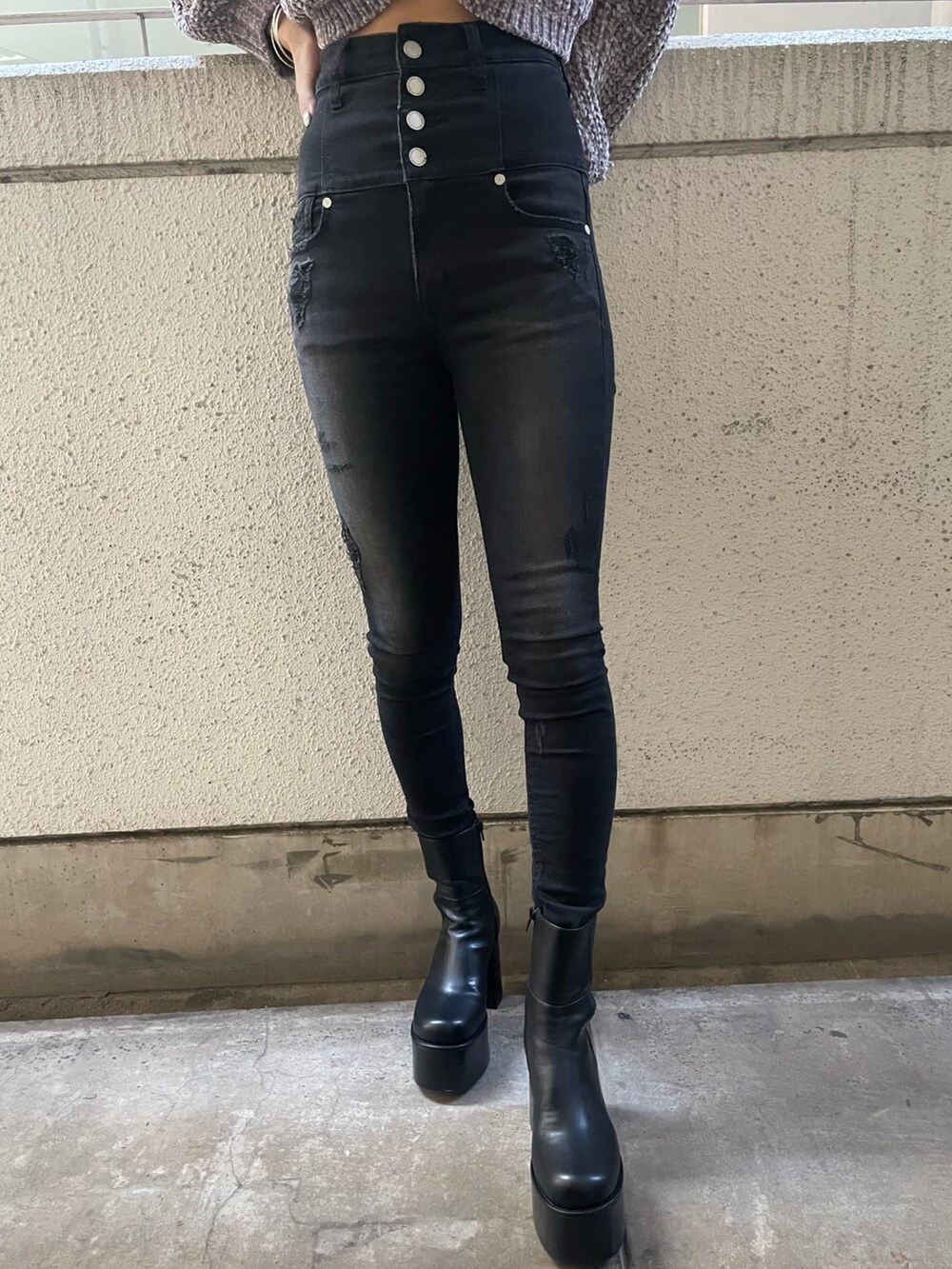 グレー系のニット/セーター、ブラック系のハンドバッグ、ブラック系のデニムパンツを着用したレディースの冬コーディネートの7枚目の写真