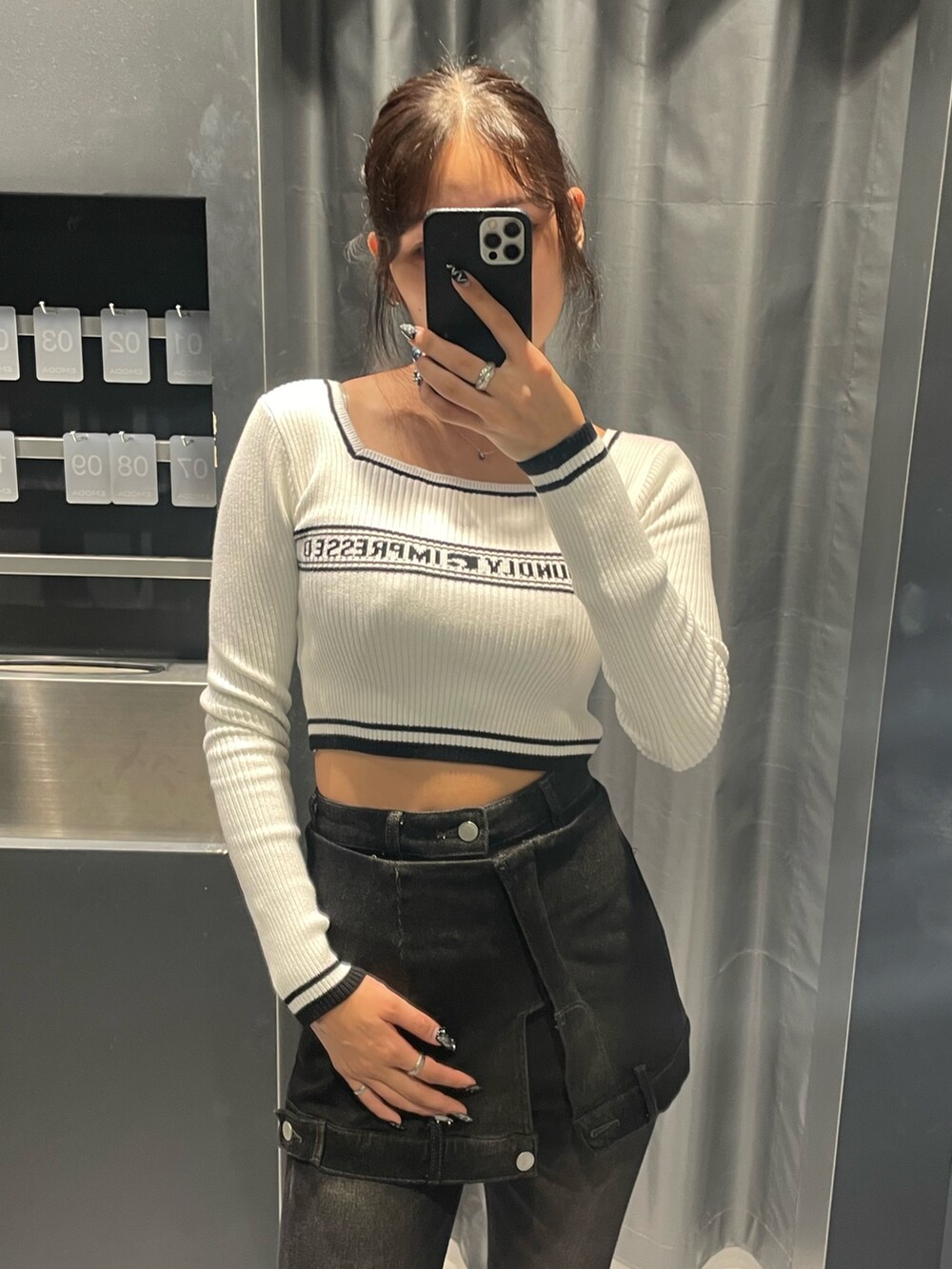 ホワイト系のニット/セーター、ブラック系のデニムパンツ、ブラック系のブーツを着用したレディースの秋コーディネートの4枚目の写真