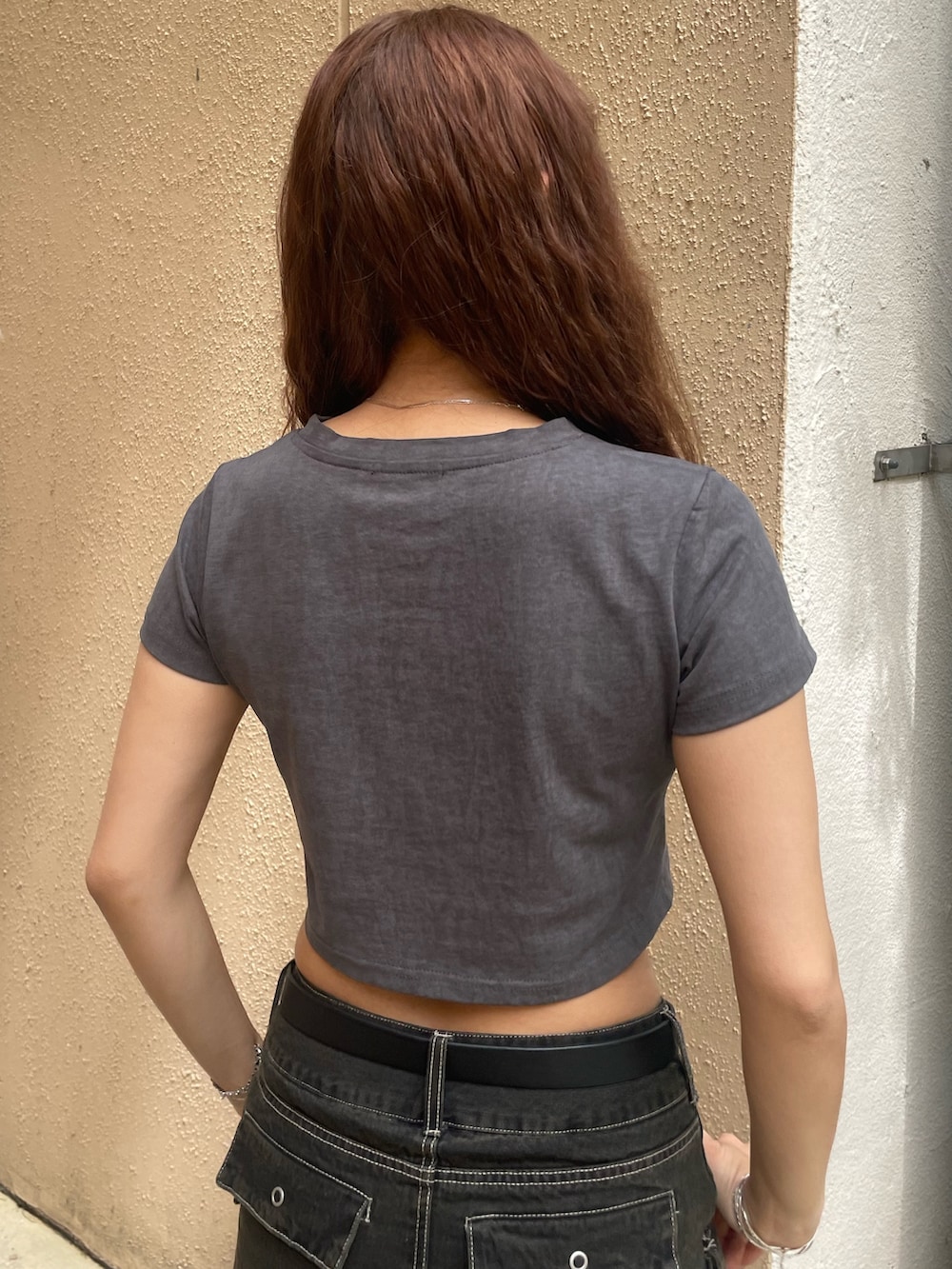 グレー系のTシャツ/カットソー、ブラック系のスカート、ブラック系のサンダルを着用したレディースの春コーディネートの6枚目の写真