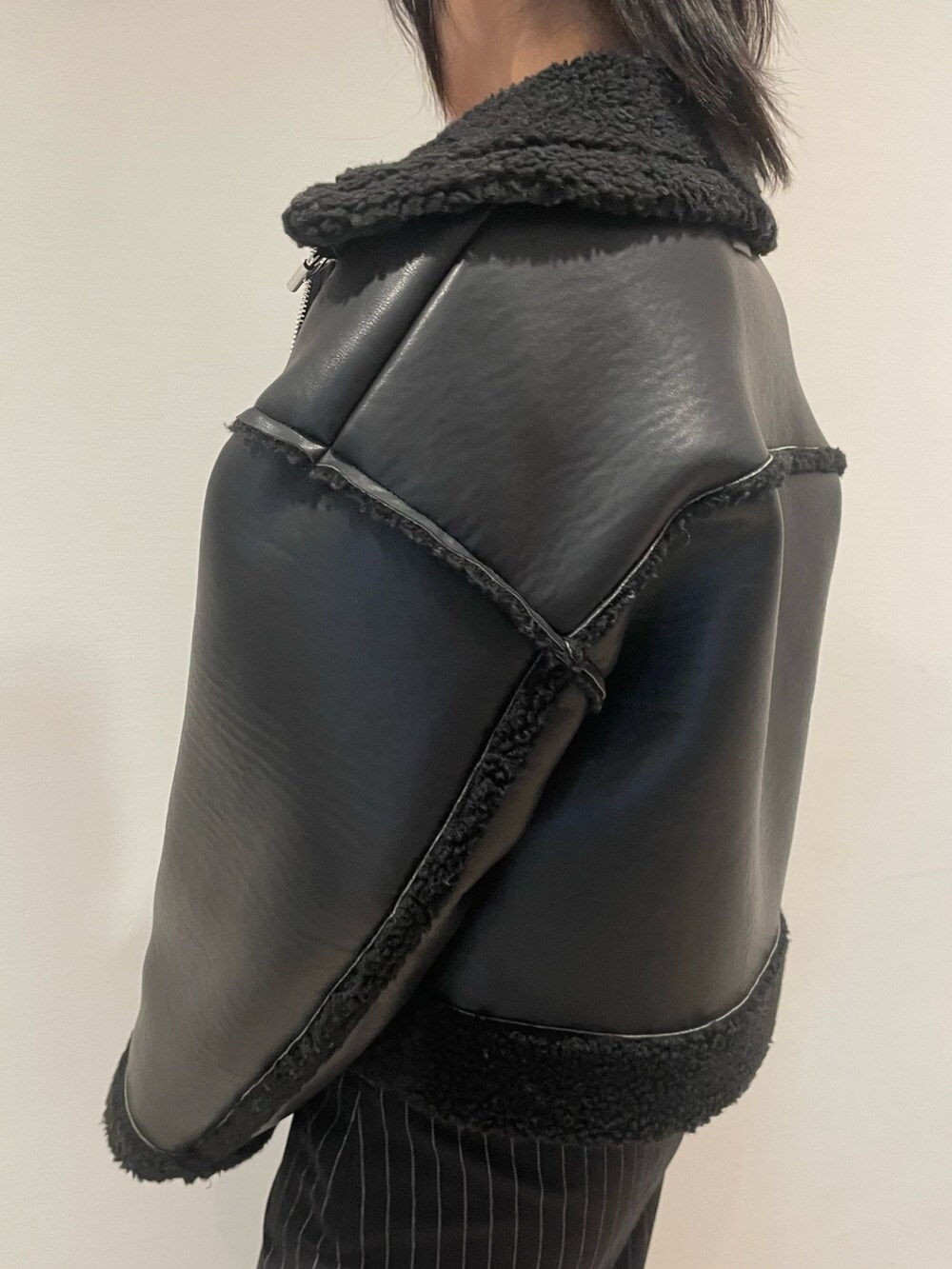 レッド系のスウェット、ブラック系のブルゾン、ブラック系のハンドバッグを着用したレディースの冬コーディネートの5枚目の写真