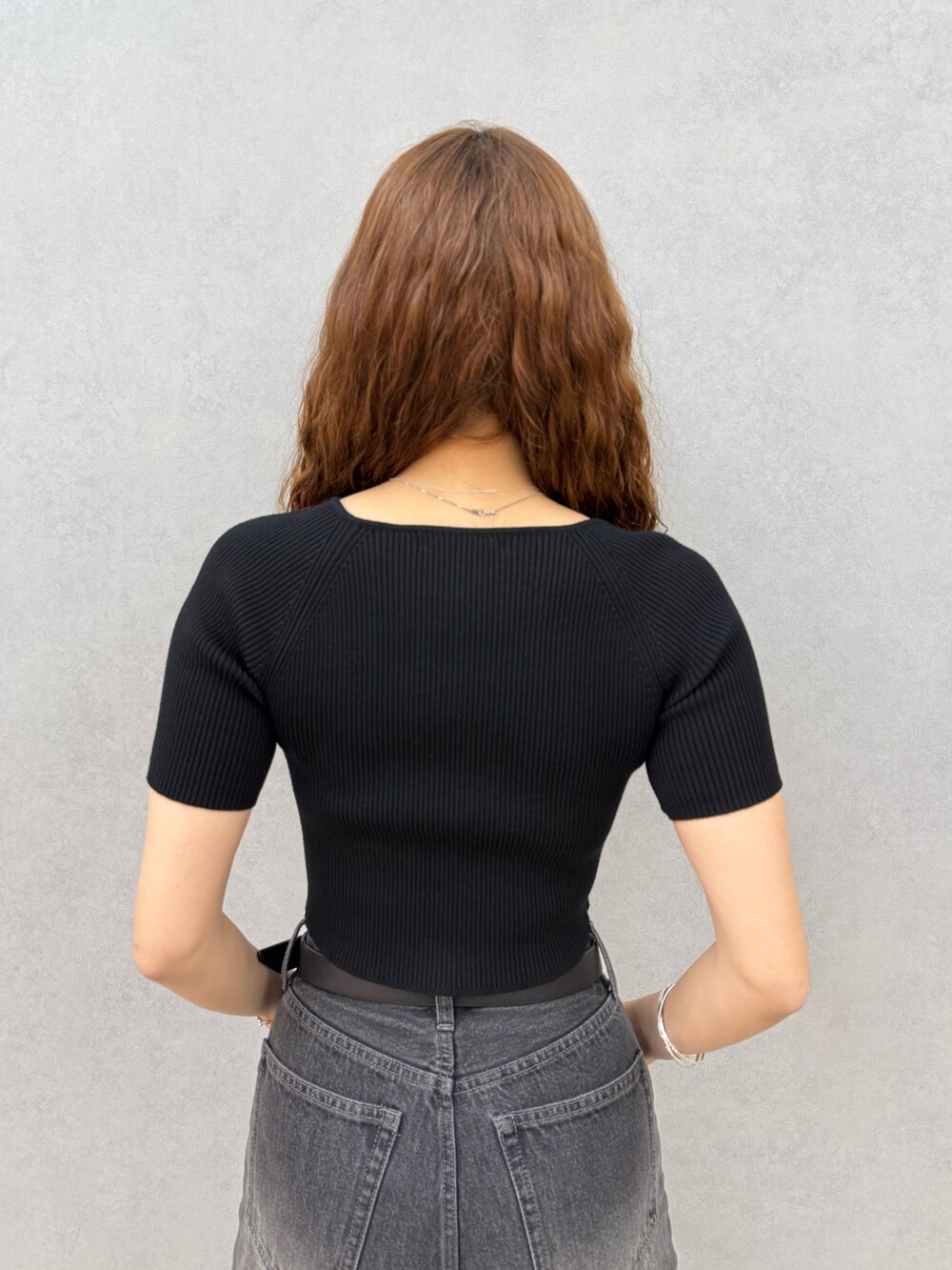 ブラック系のニット/セーター、ブラック系のデニムパンツ、ブラック系のサンダルを着用したレディースの夏コーディネートの6枚目の写真