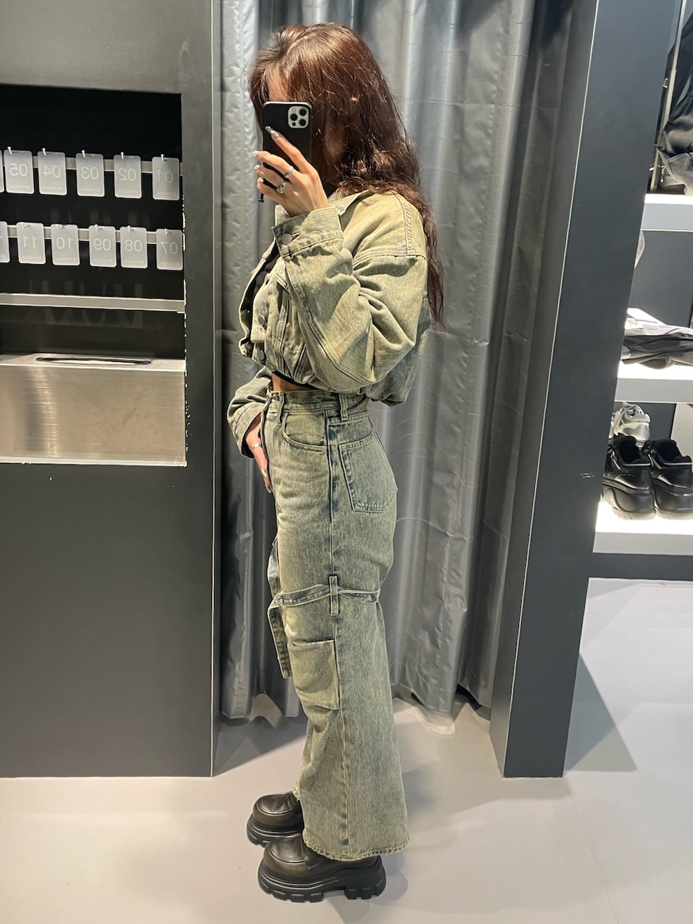 ブラック系のニット/セーター、ブルー系のデニムジャケット、ブルー系のデニムパンツを着用したレディースの冬コーディネートの2枚目の写真