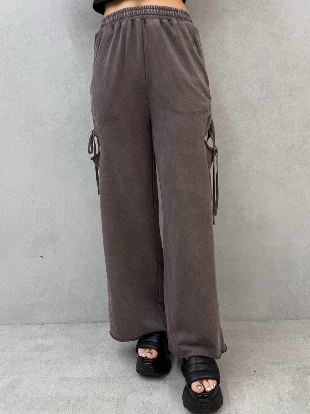 ブラック系のTシャツ/カットソー、ブラウン系のスウェットパンツ、ブラック系のサンダルを着用したレディースの夏コーディネートの7枚目の写真