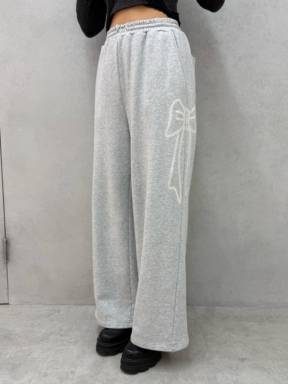 ブラック系のパーカー、グレー系のスウェットパンツ、ブラック系のブーツを着用したレディースの冬コーディネートの5枚目の写真