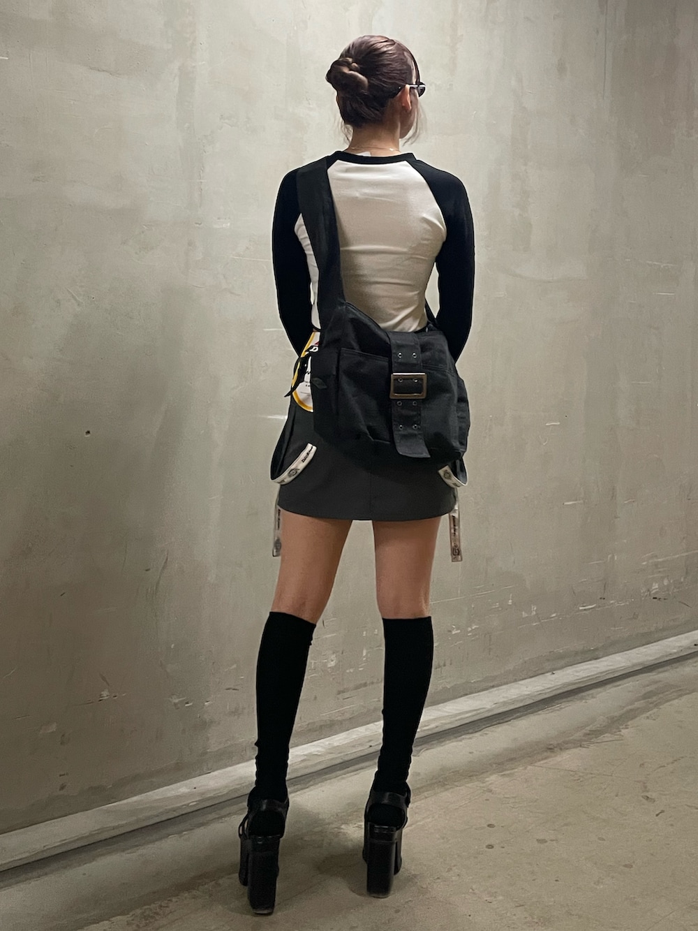 ブラック系のハンドバッグ、ホワイト系のTシャツ/カットソー、グレー系のスカートを着用したレディースの春コーディネートの3枚目の写真