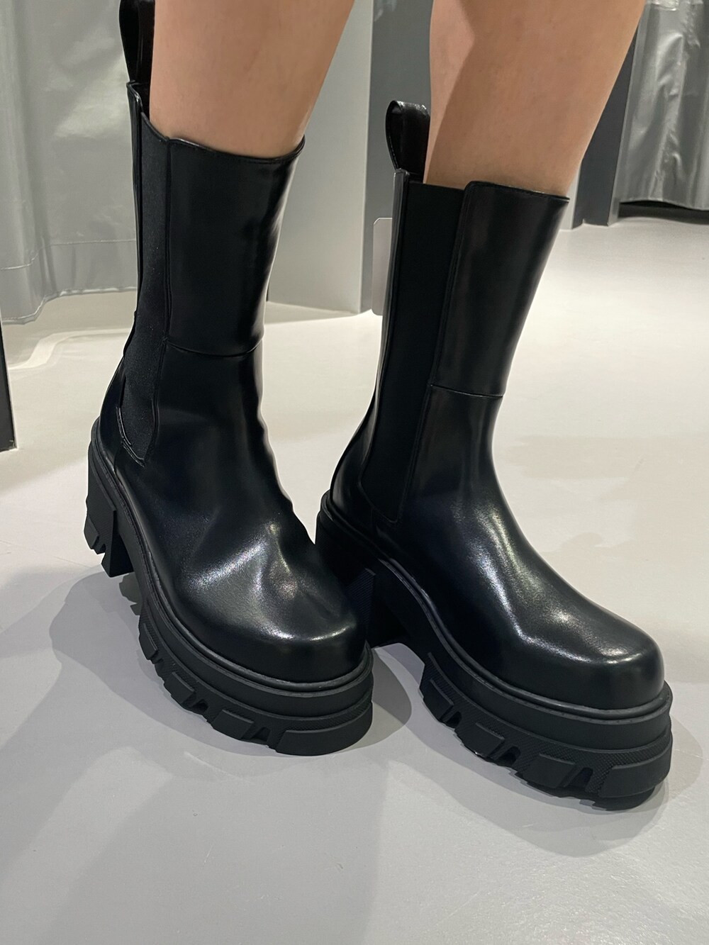 レッド系のTシャツ/カットソー、ブルー系のデニムパンツ、ブラック系のブーツを着用したレディースの秋コーディネートの9枚目の写真